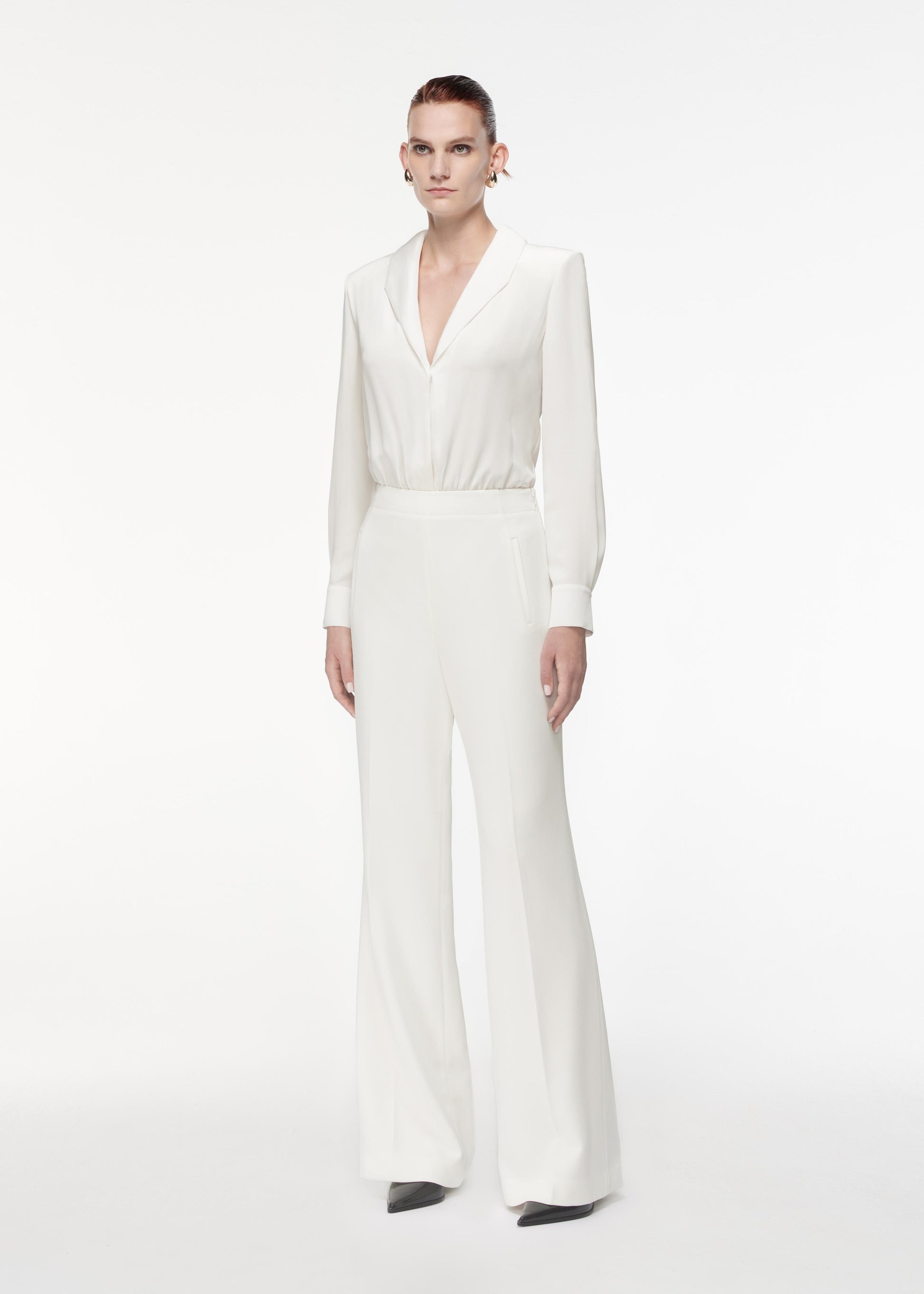 Side view of a model wearing the High Waisted Wide Leg Trouser in White