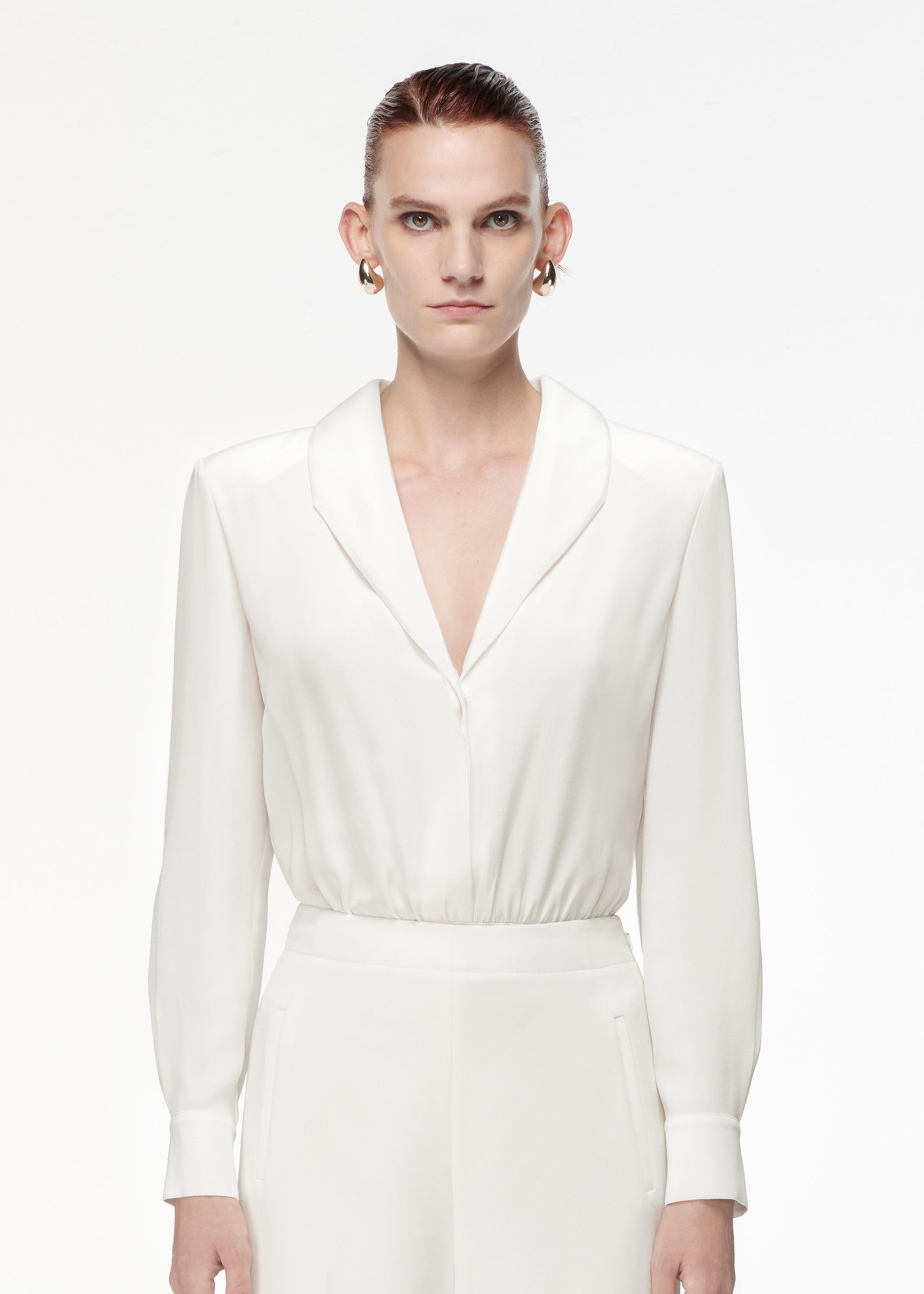 Close up of a model wearing the High Waisted Wide Leg Trouser in White