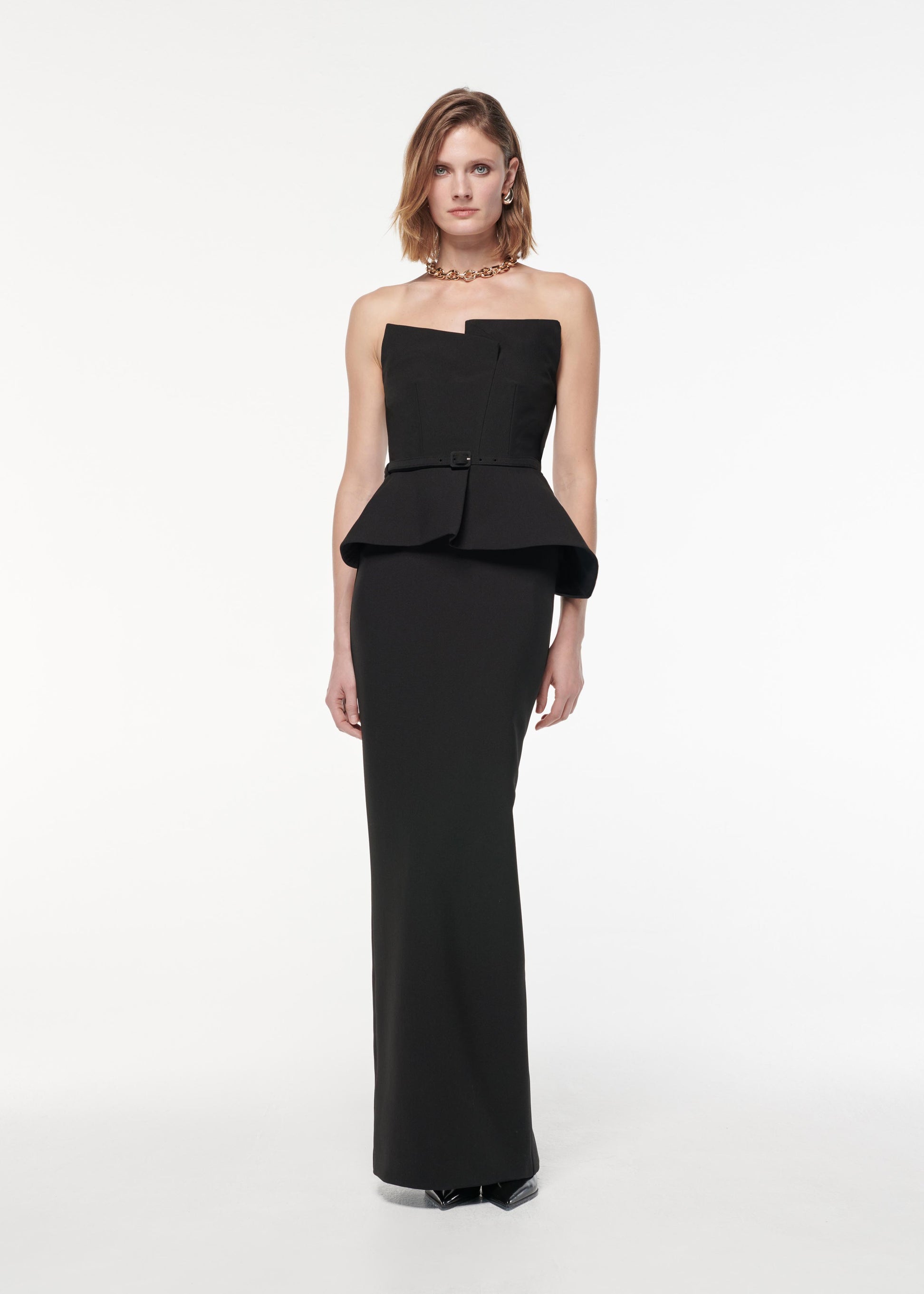 A photograph of a woman wearing a Strapless Draped Crepe Gown in Black