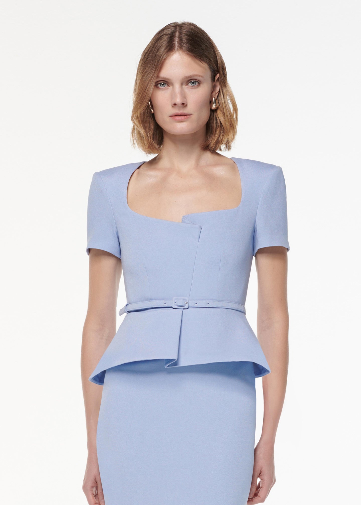 A photograph of a woman wearing a Short Sleeve Stretch Wool Silk Midi Dress in Blue