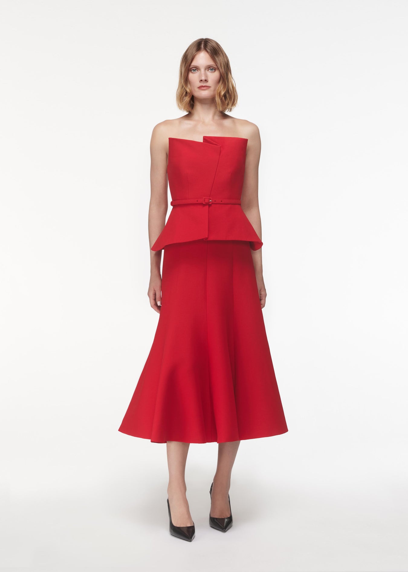 A photograph of a woman wearing a Strapless Wool Silk Peplum Midi Dress in Red
