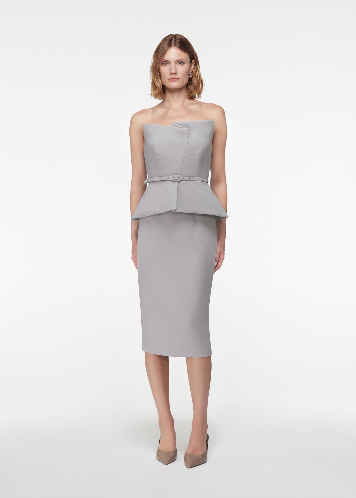 A photograph of a woman wearing a Strapless Crepe Peplum Top in Grey