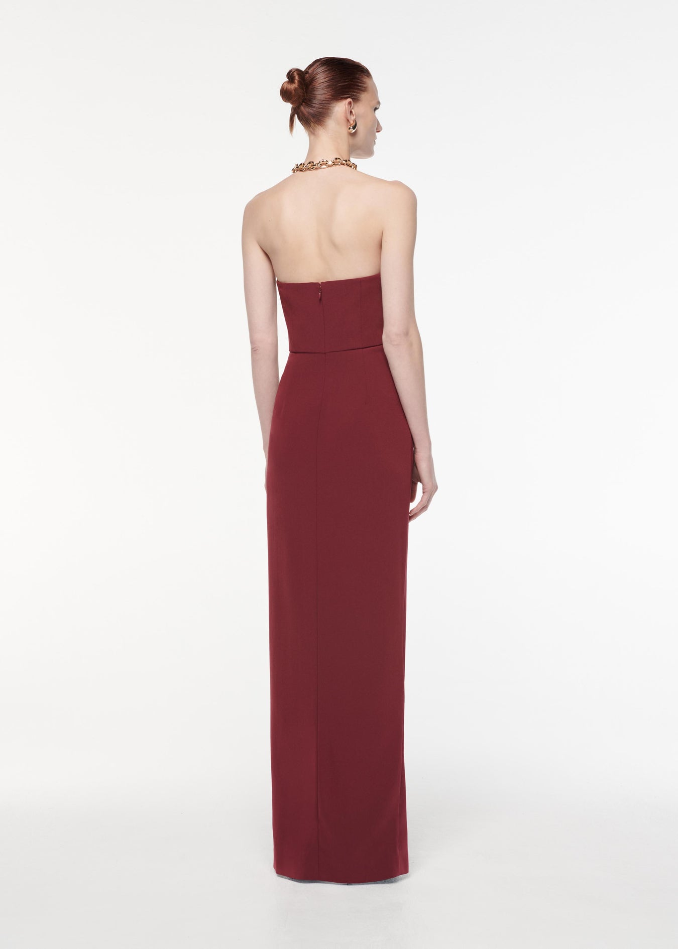 A photograph of a woman wearing a Strapless Satin Crepe Gown in Burgundy