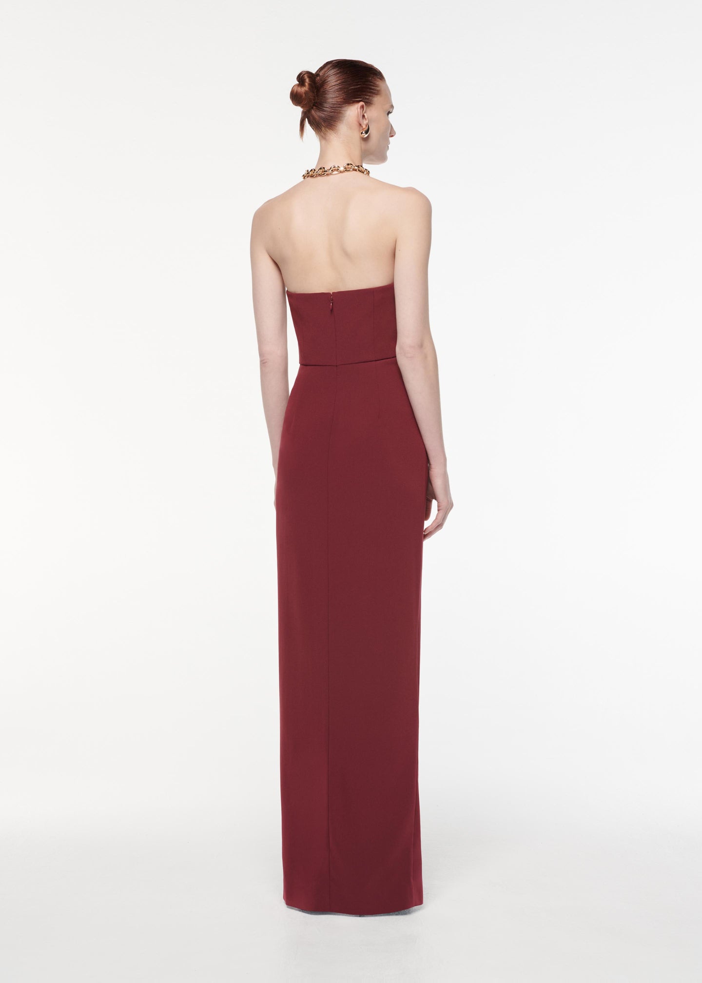 A photograph of a woman wearing a Strapless Satin Crepe Gown in Burgundy