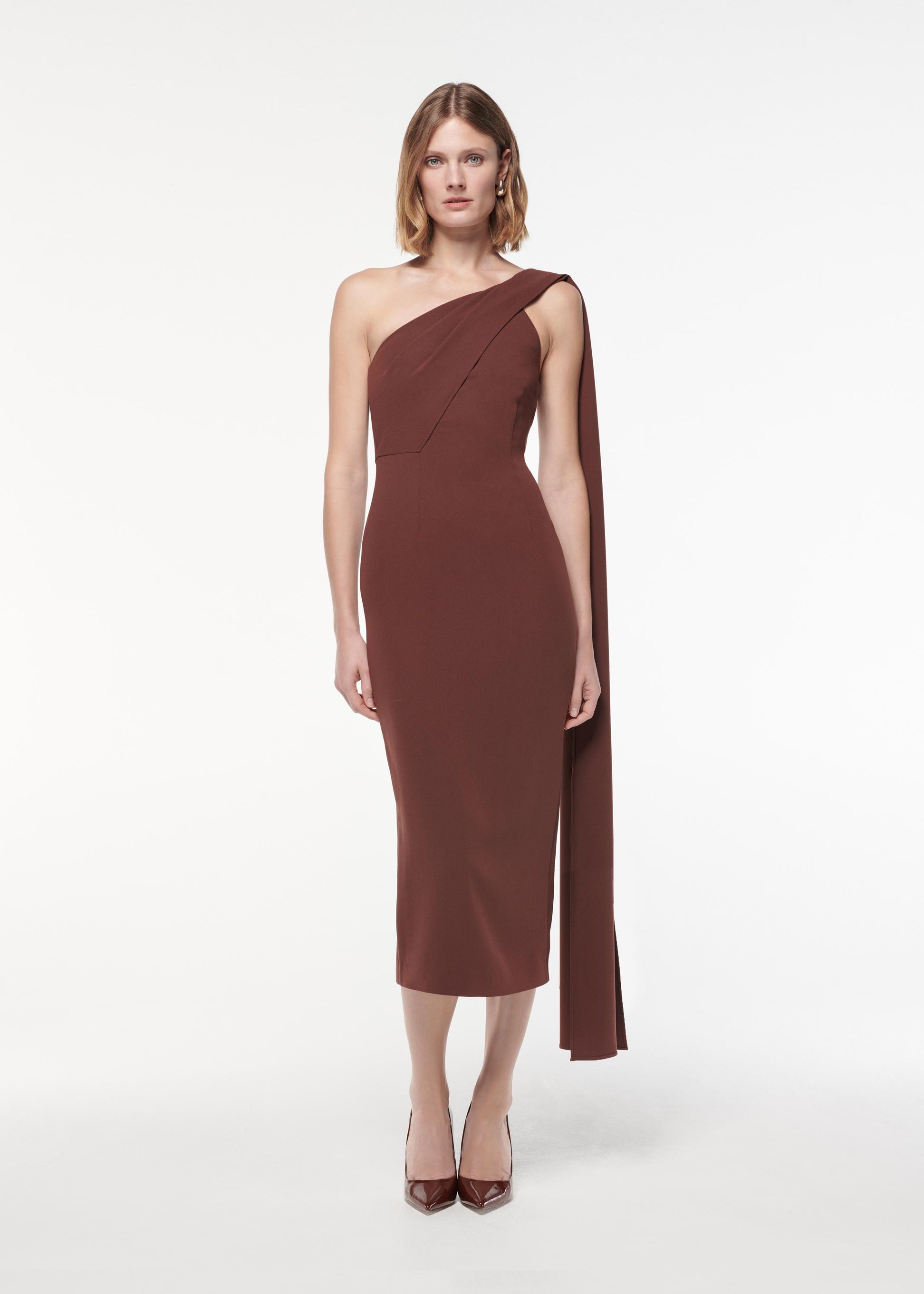 A photograph of a woman wearing a Asymmetric Heavy Cady Midi Dress in Brown