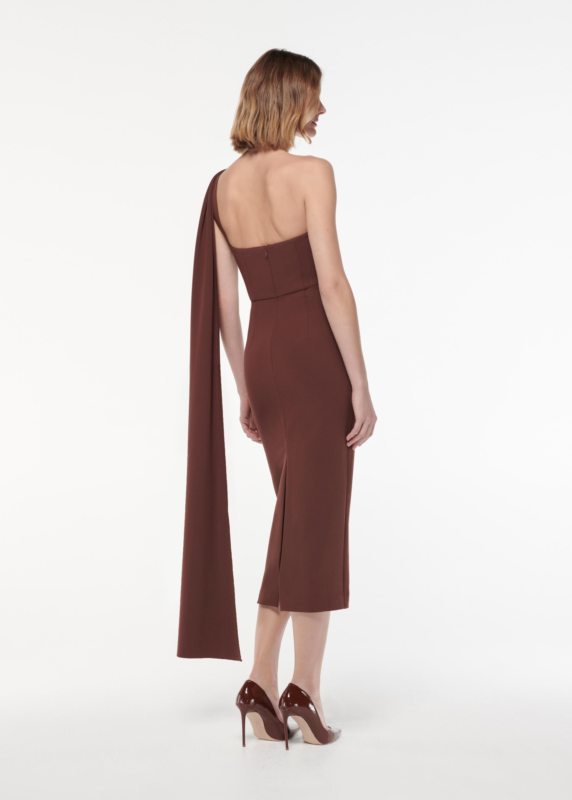 A photograph of a woman wearing a Asymmetric Heavy Cady Midi Dress in Brown