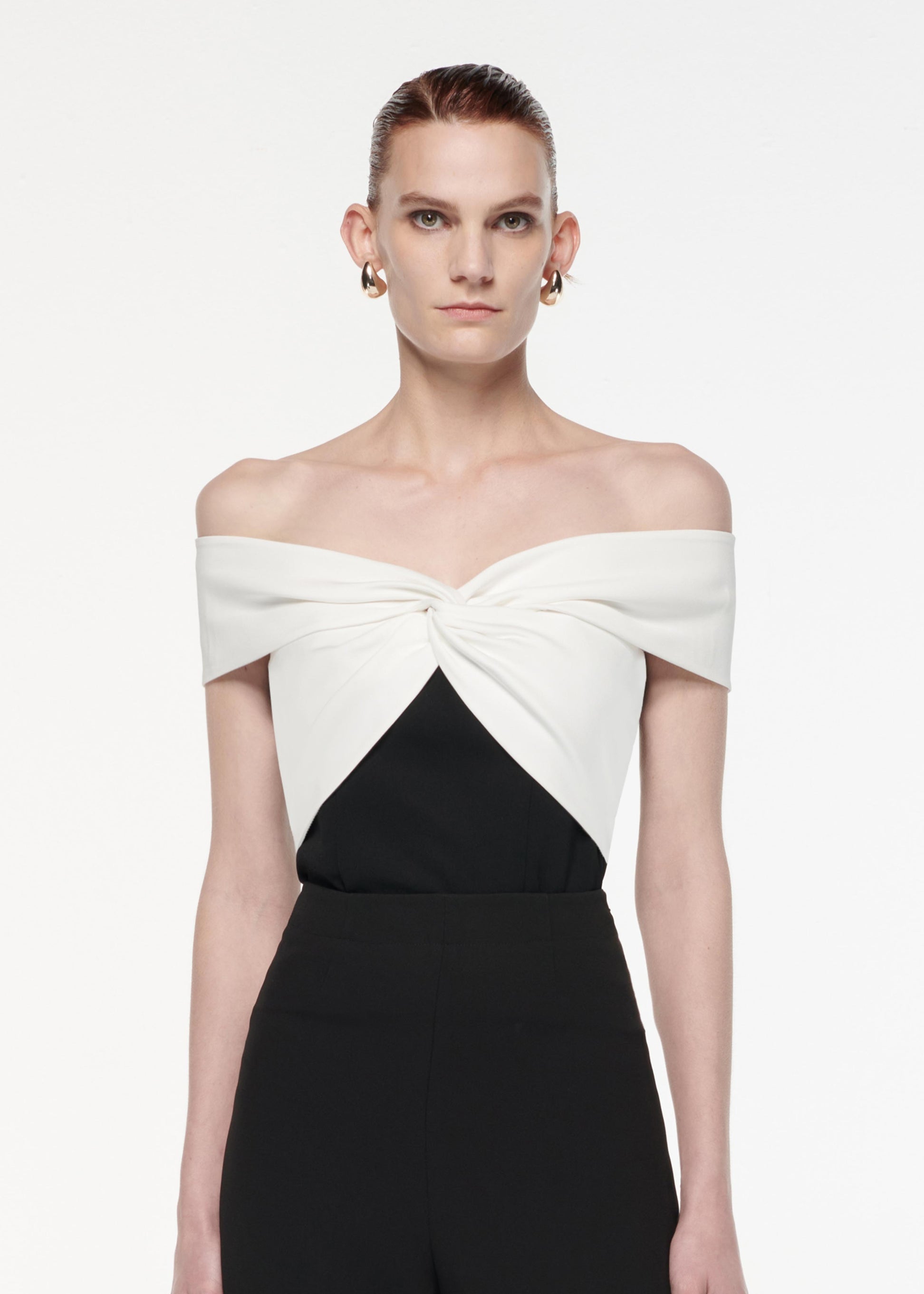 A photograph of a woman wearing a Off The Shoulder Light Cady Top in Monochrome