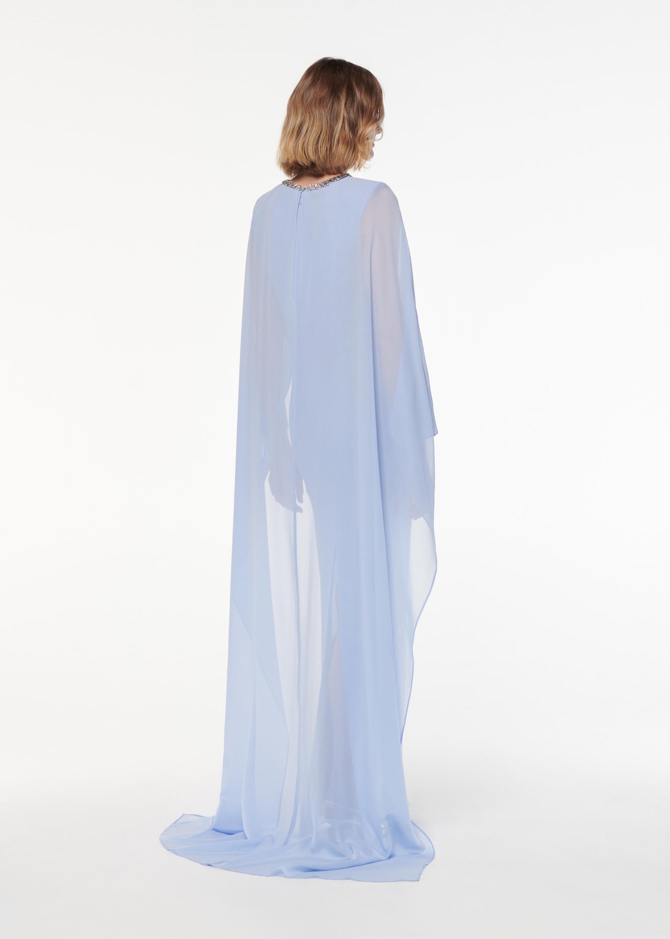 A photograph of a woman wearing a Silk Chiffon Diamante Gown in Blue