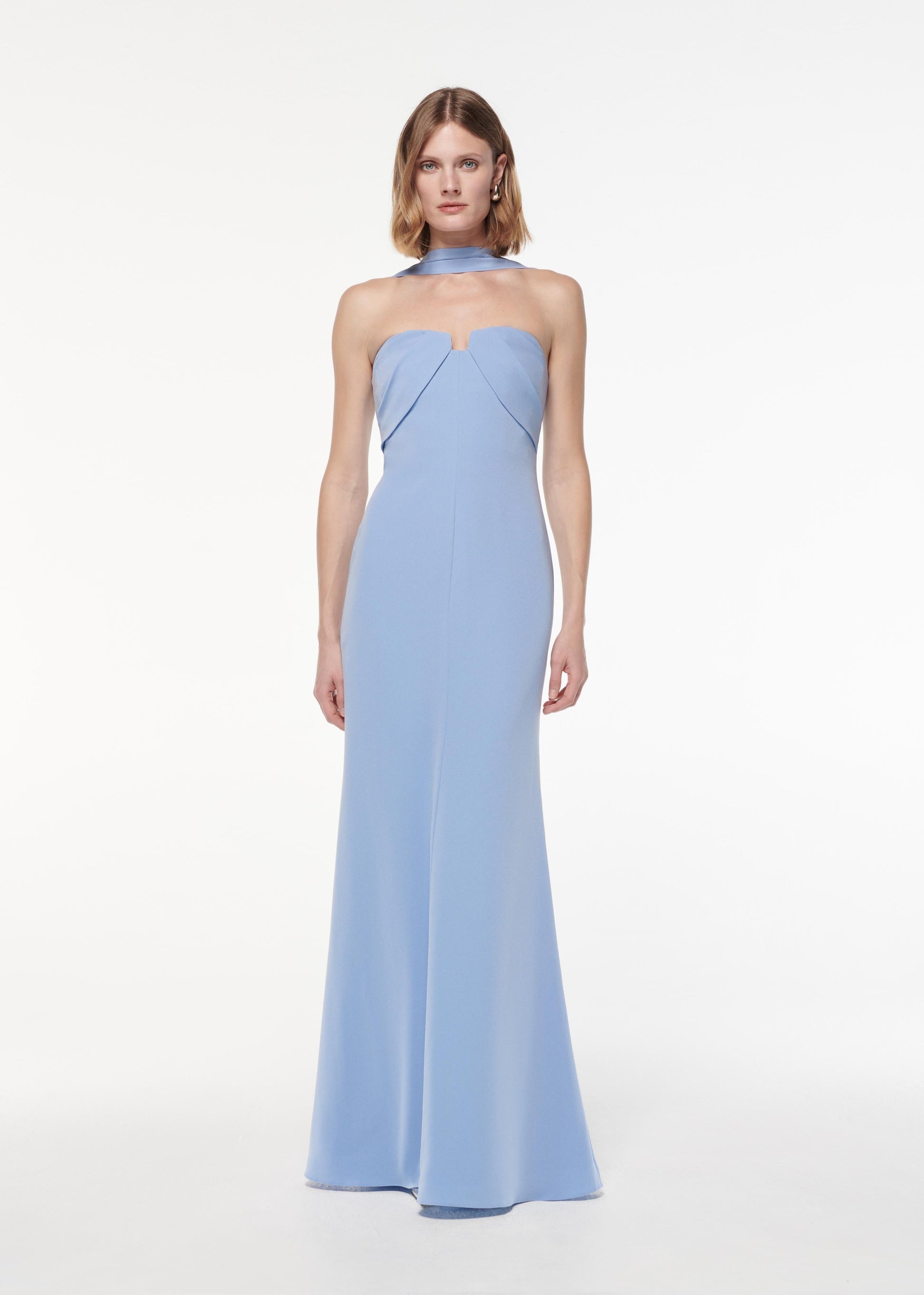 A photograph of a woman wearing a Sash Satin Crepe Gown in Blue