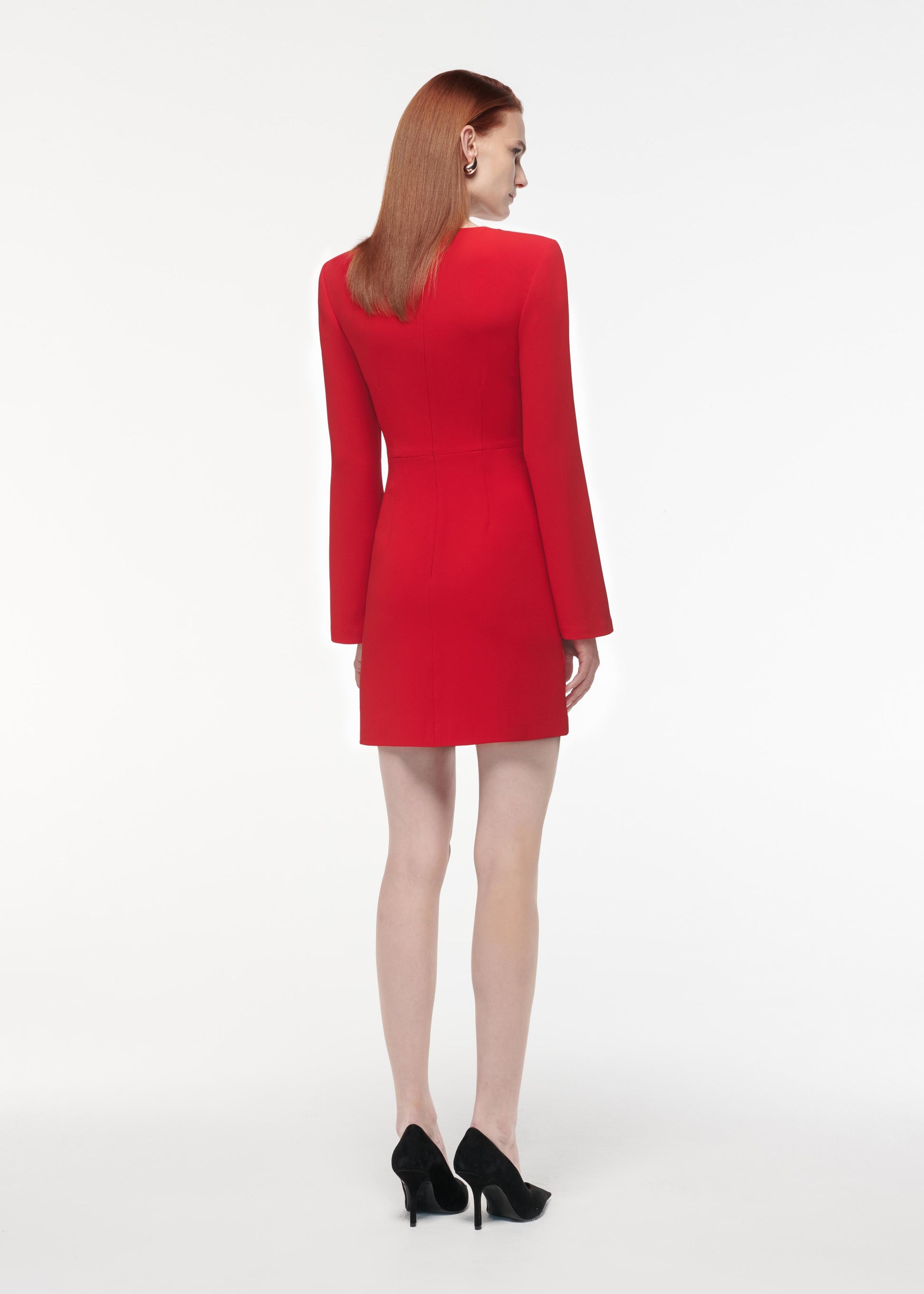 A photograph of a woman wearing a Long Sleeve Flower Detail Mini Dress in Red
