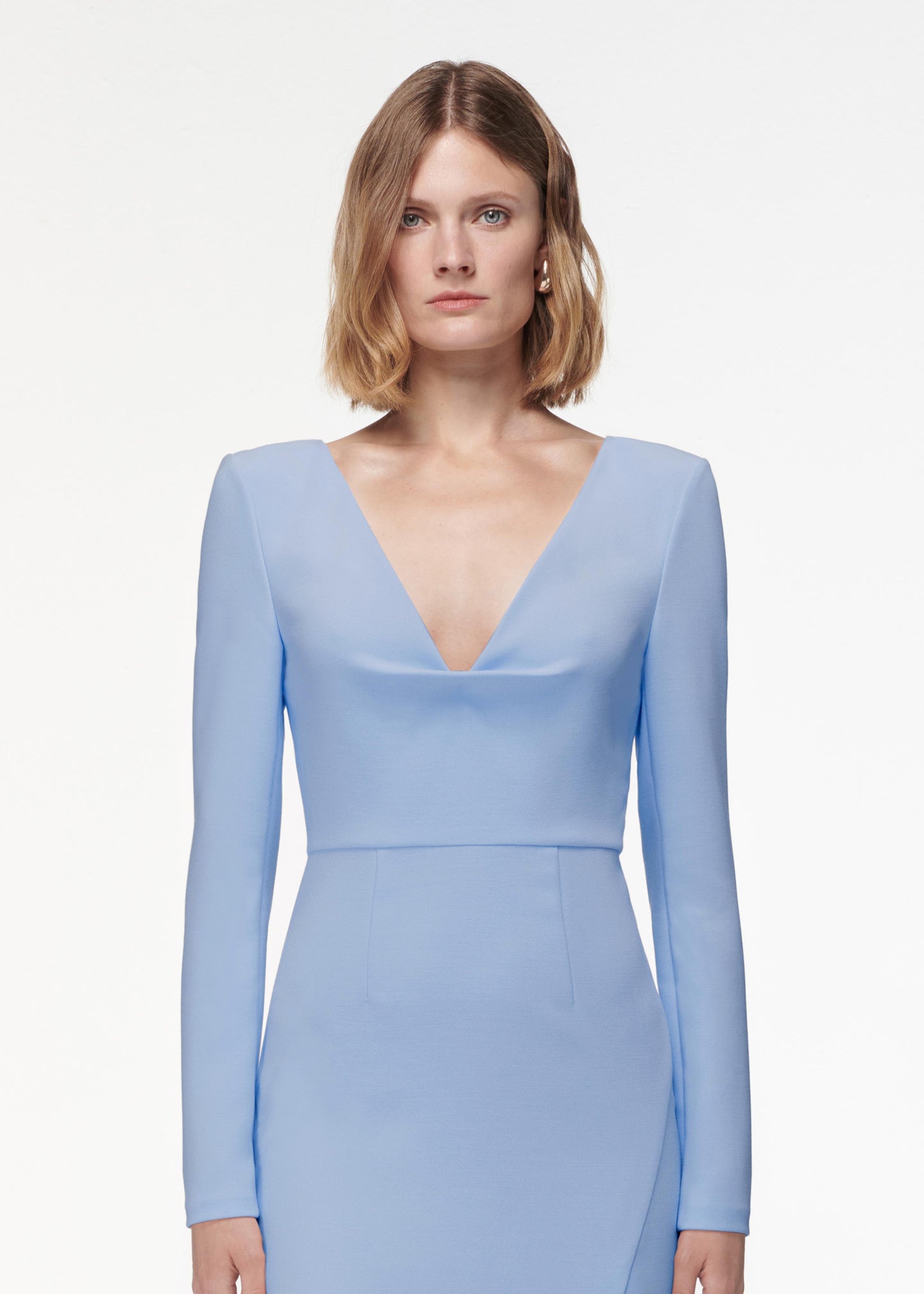 A photograph of a woman wearing a Long Sleeve Crepe Midi Dress Light in Blue