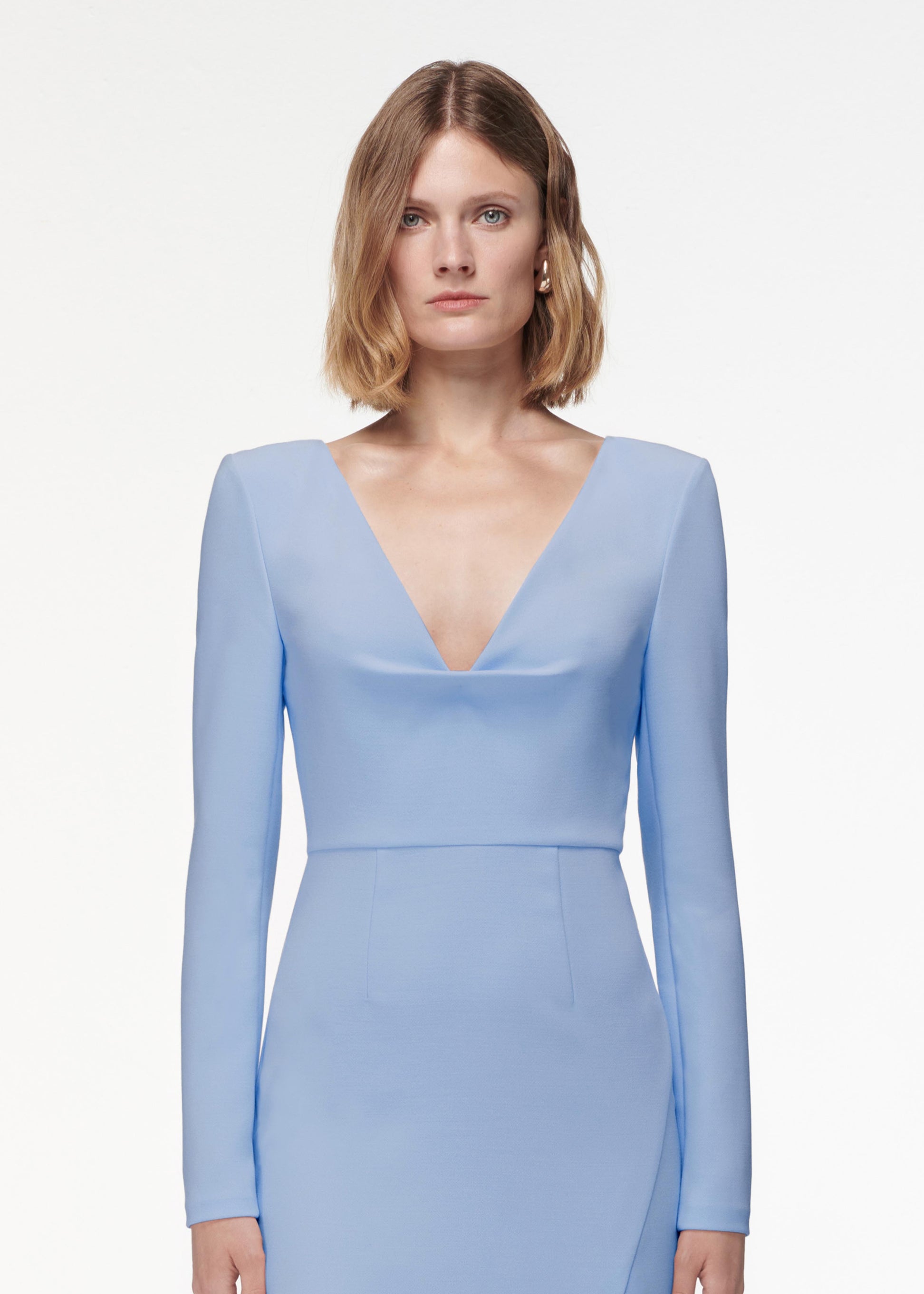 A photograph of a woman wearing a Long Sleeve Crepe Midi Dress Light in Blue
