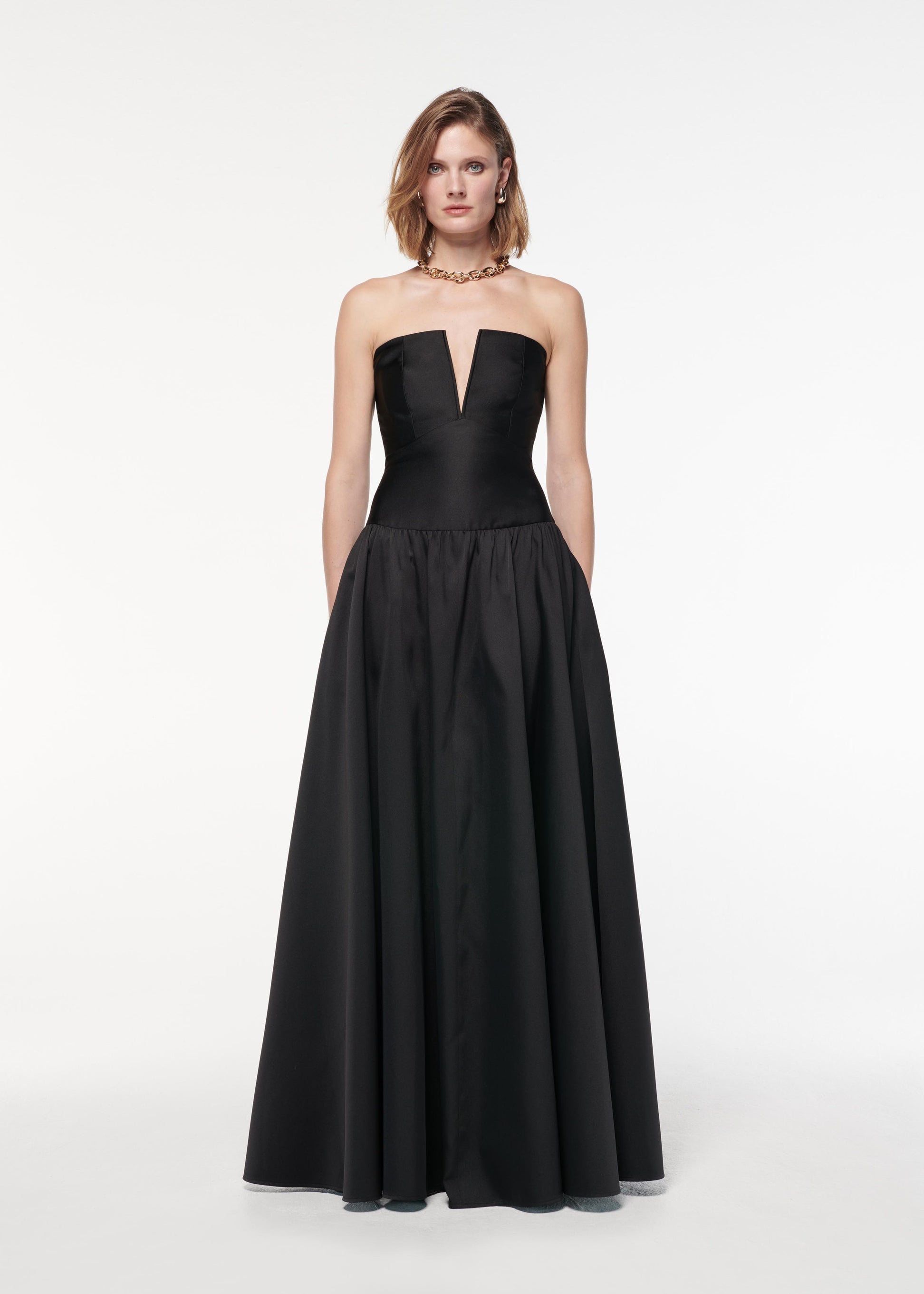 A photograph of a woman wearing a Strapless Taffeta Gown in Black