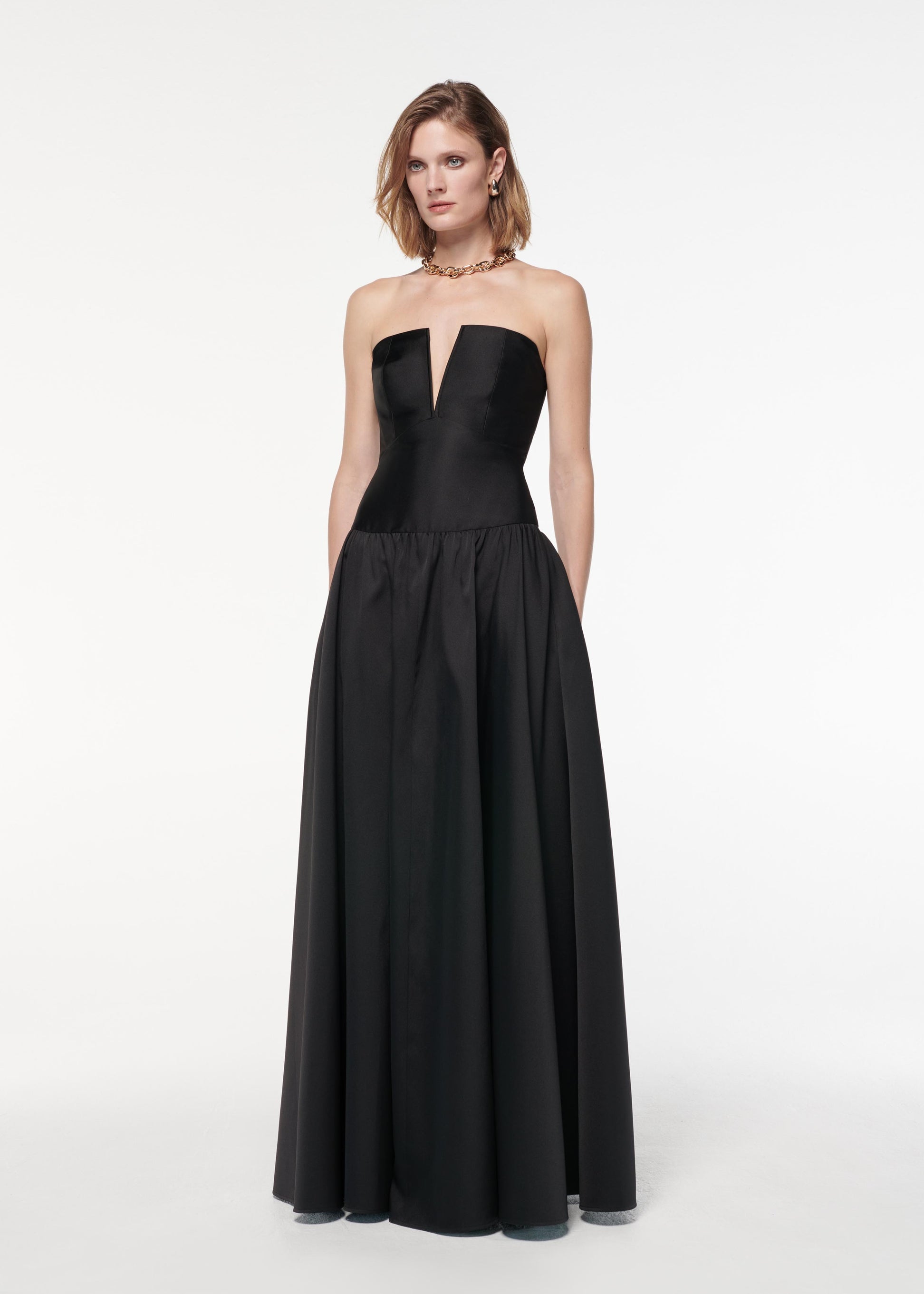 A photograph of a woman wearing a Strapless Taffeta Gown in Black