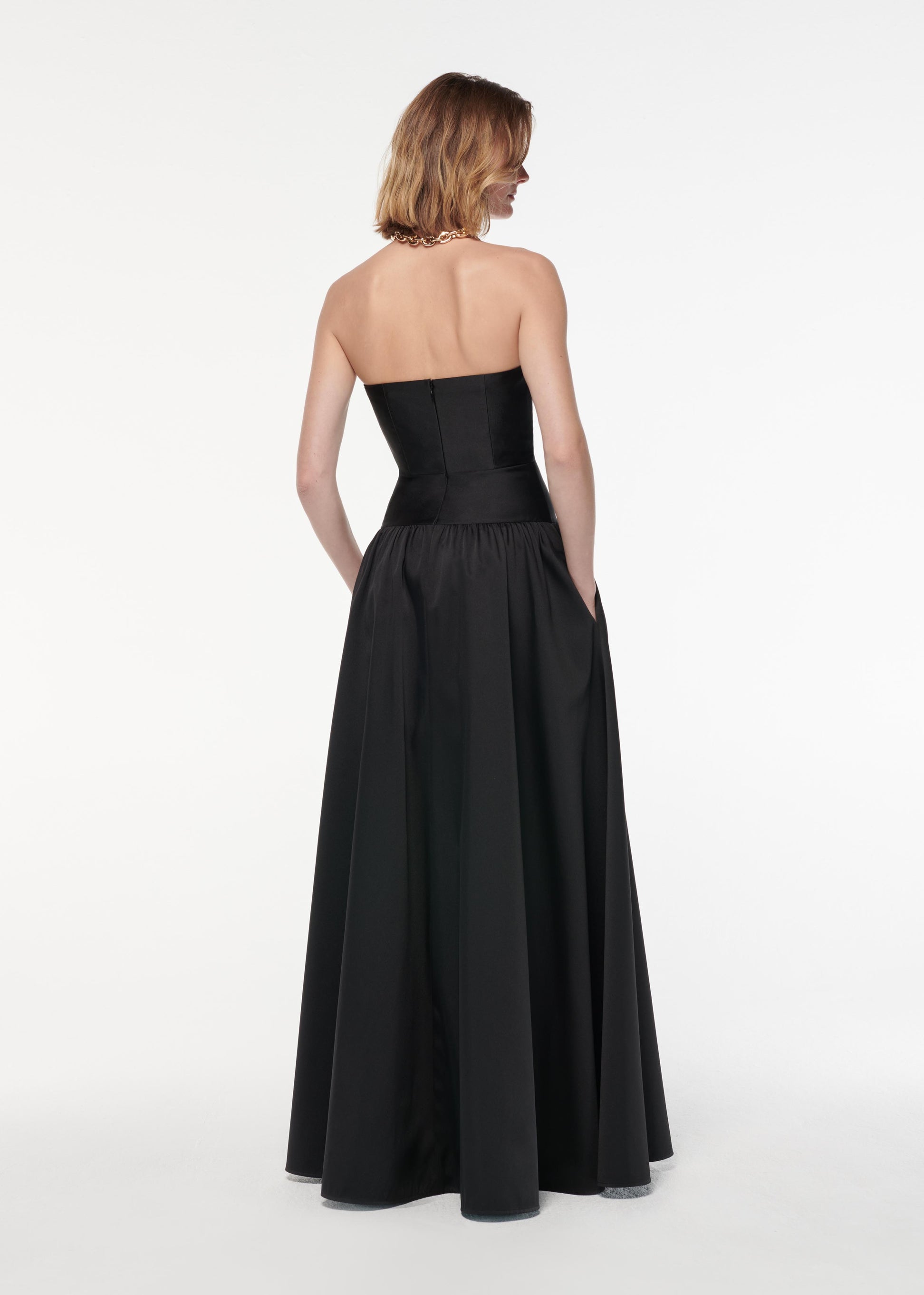 A photograph of a woman wearing a Strapless Taffeta Gown in Black
