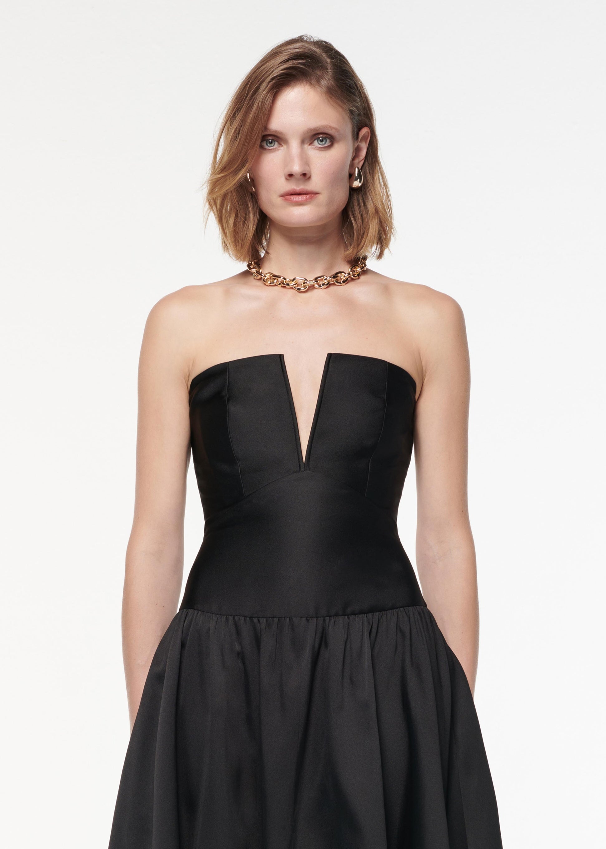 A photograph of a woman wearing a Strapless Taffeta Gown in Black