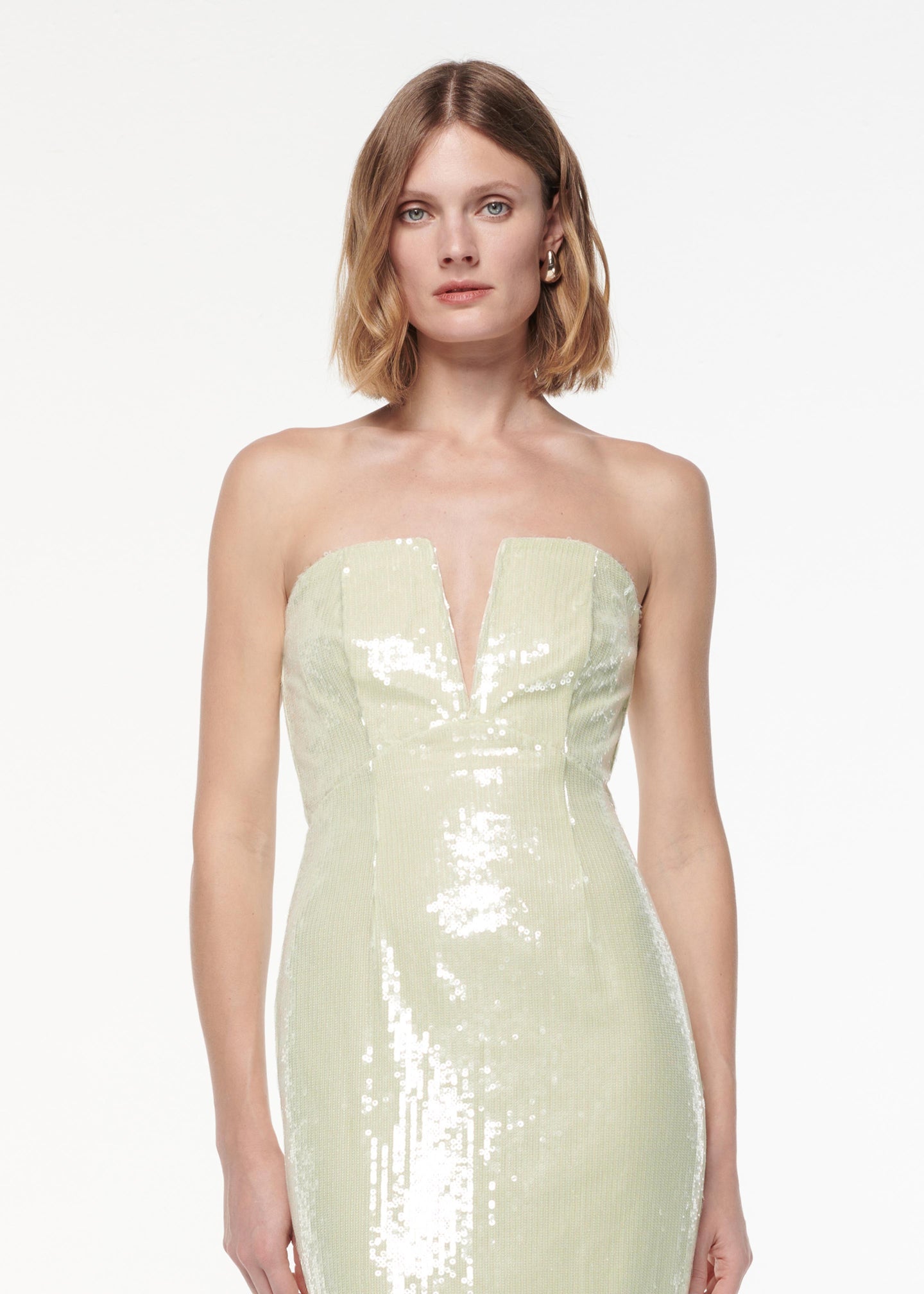 A photograph of a woman wearing a Strapless V Neck Sequin Midi Dress in Green