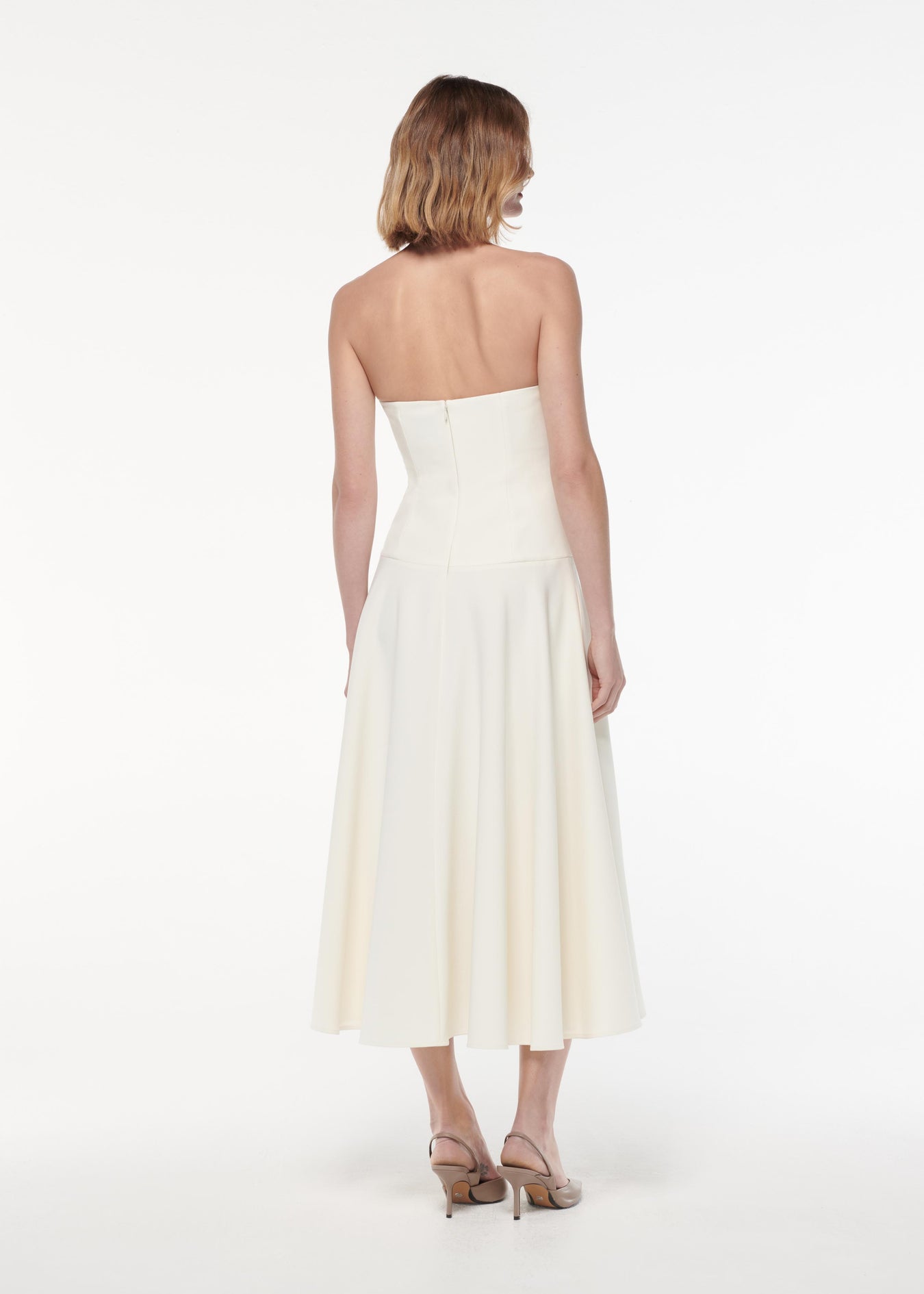 A photograph of a woman wearing a Strapless Crepe Midi Dress in Cream
