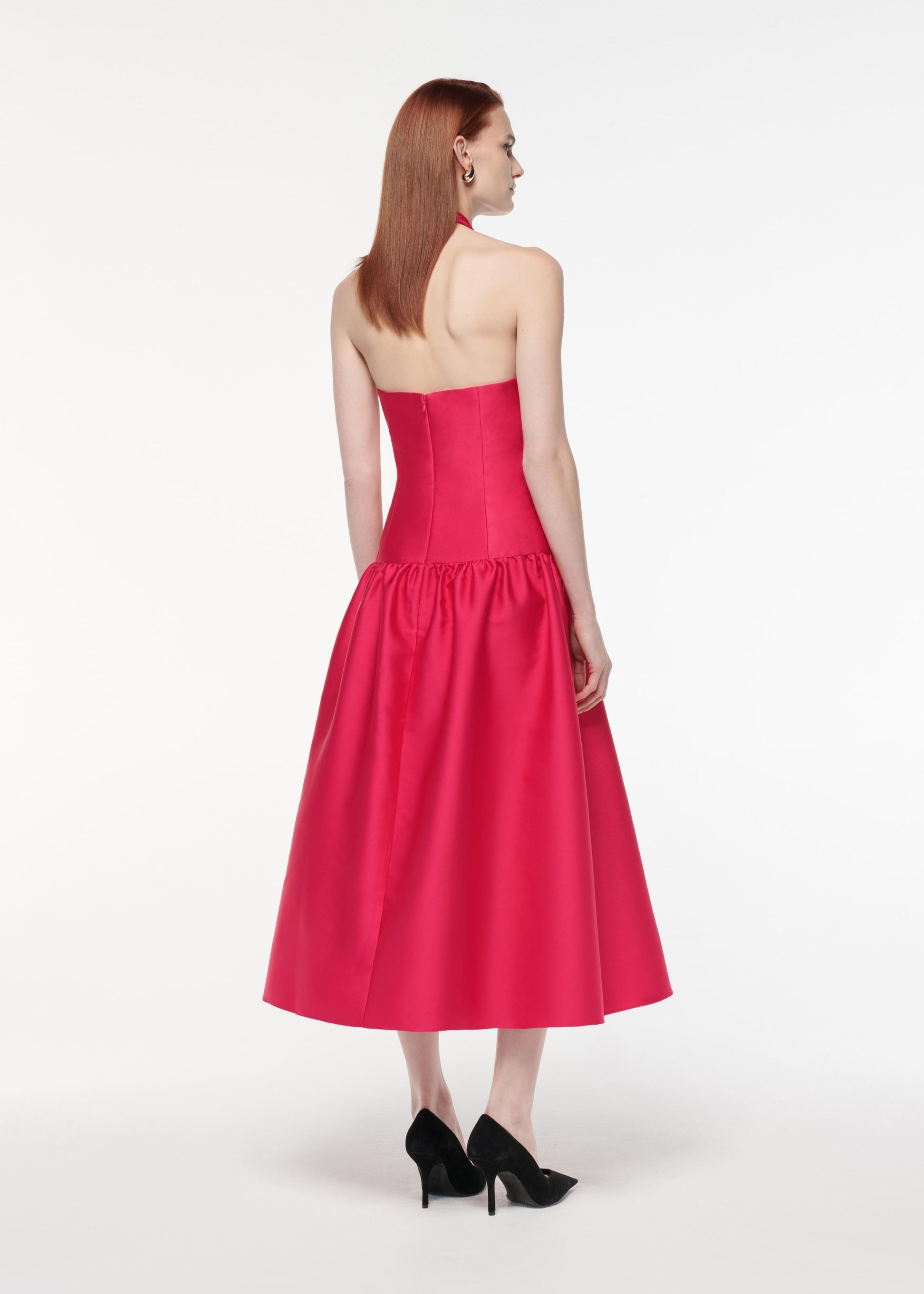A photograph of a woman wearing a Taffeta Midi Dress in Pink