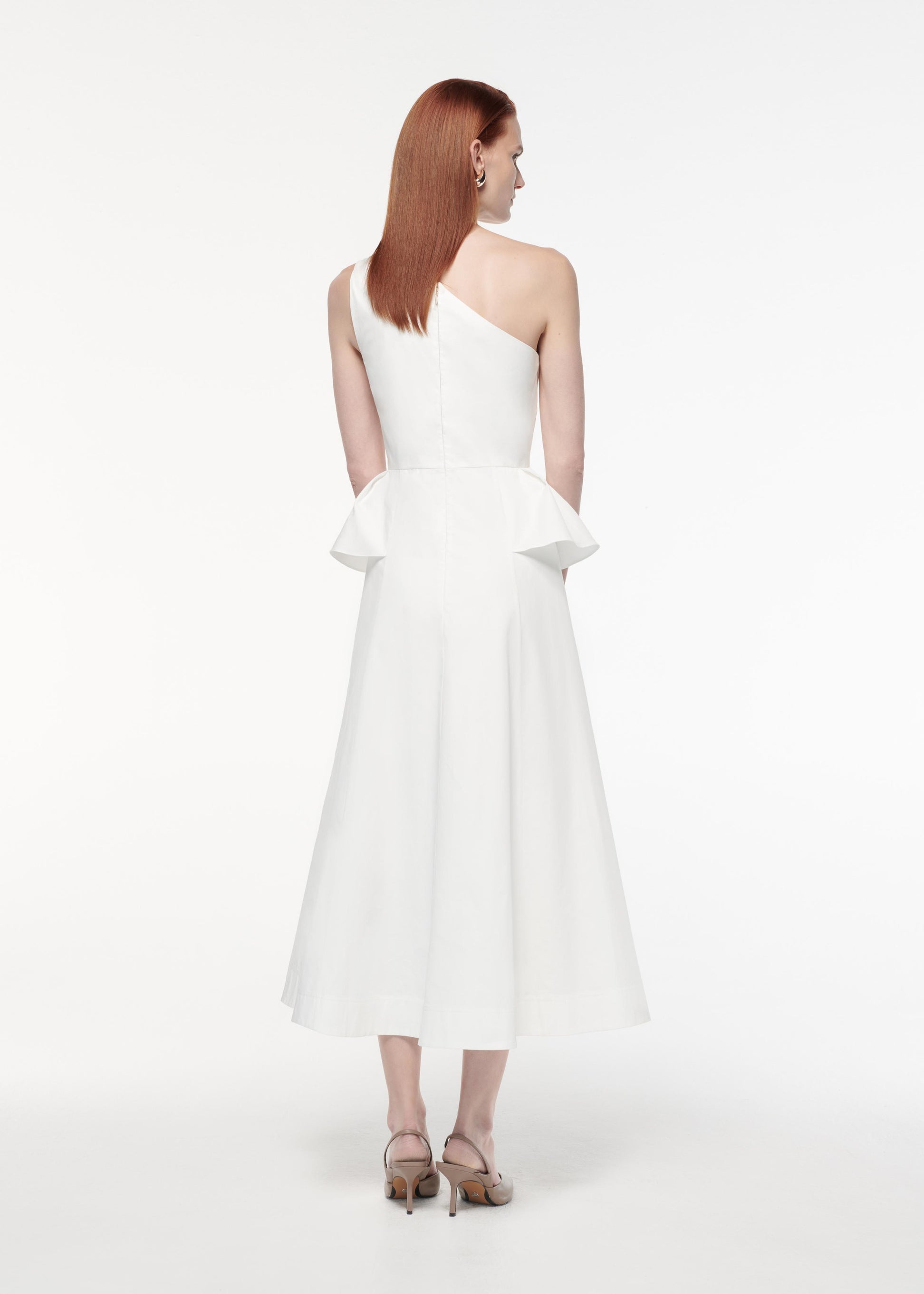 A photograph of a woman wearing a Asymmetric Hip Detail Dress in White