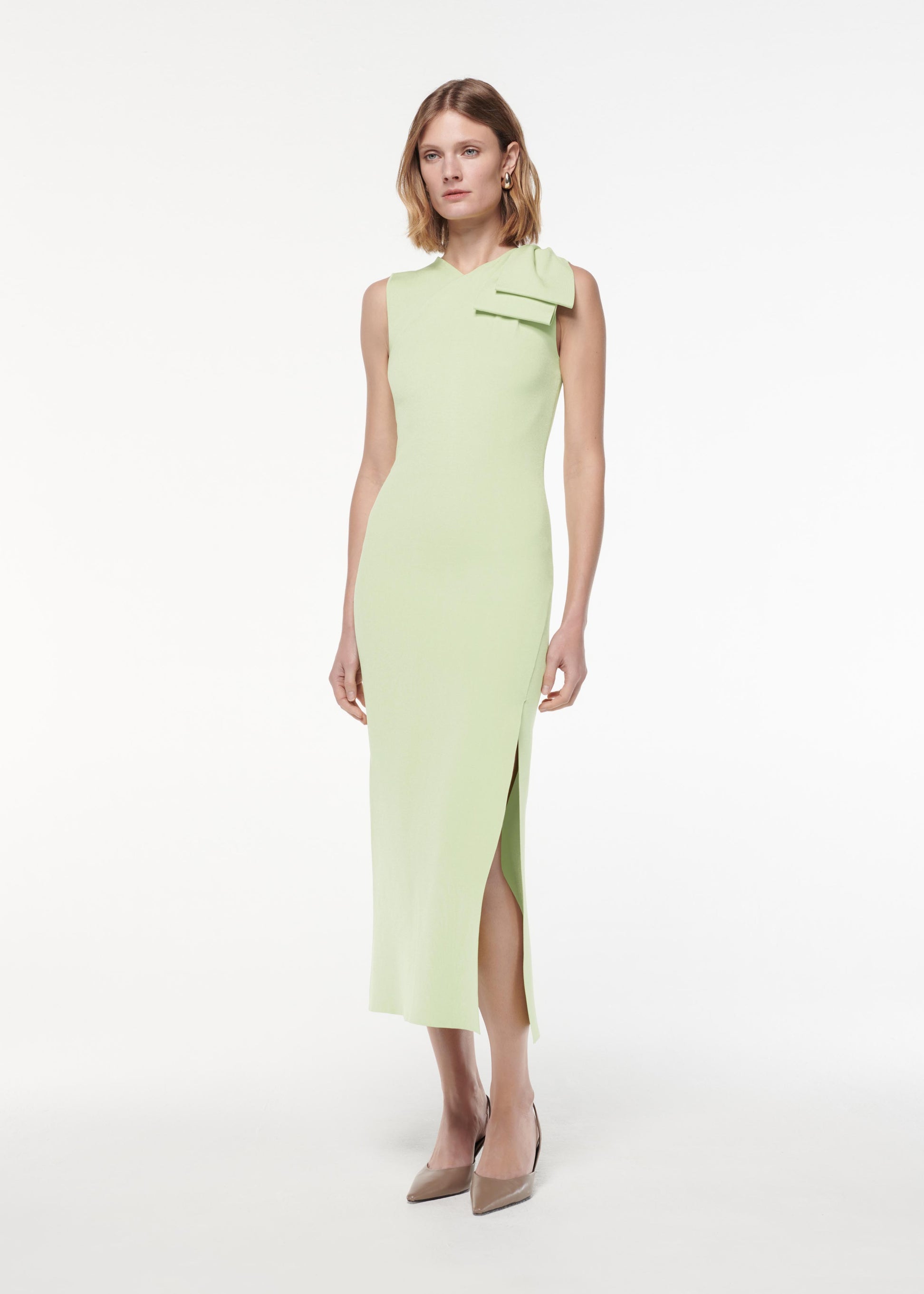 A photograph of a woman wearing a Flat Knit Bow Midi Dress in Green