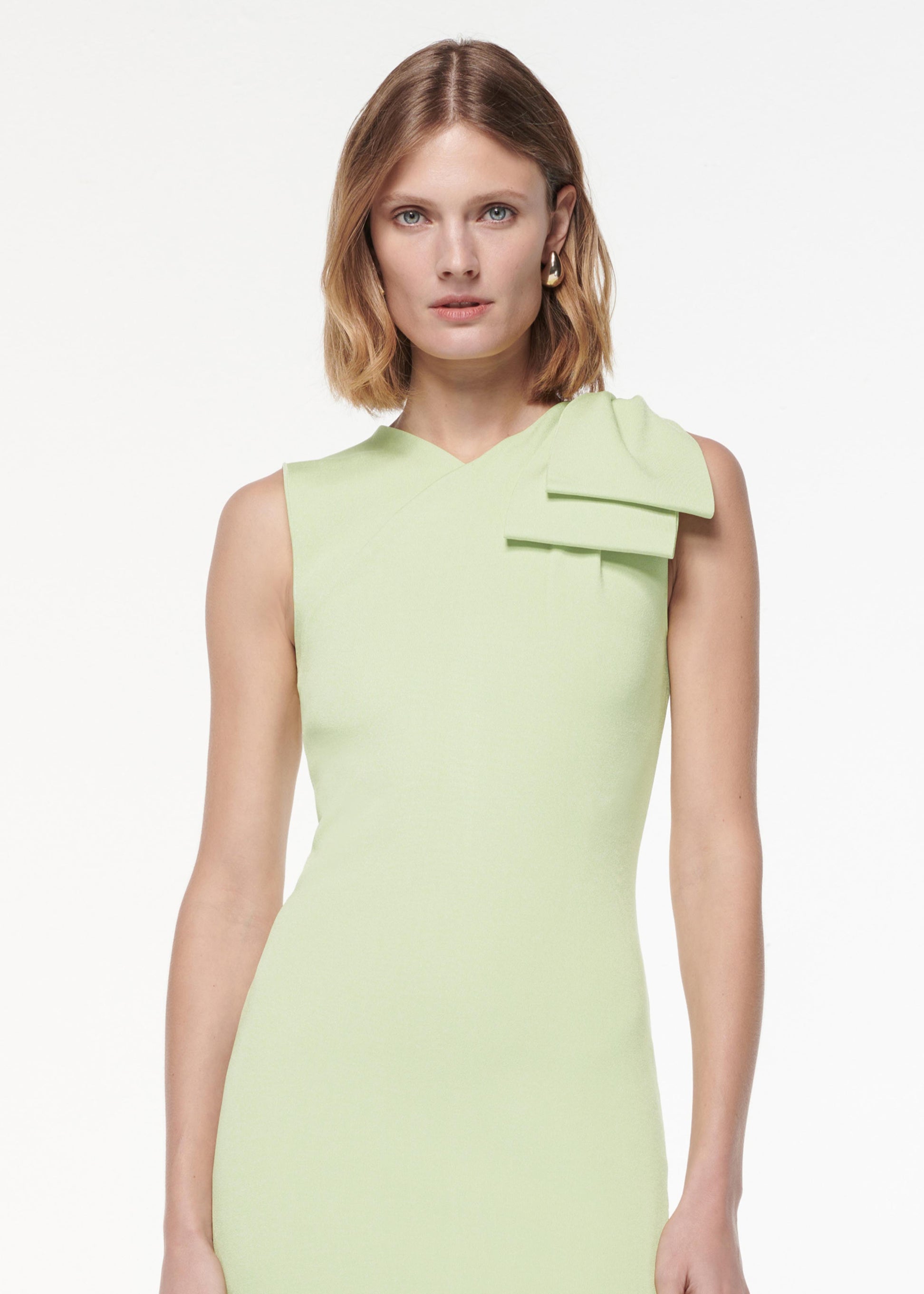 A photograph of a woman wearing a Flat Knit Bow Midi Dress in Green