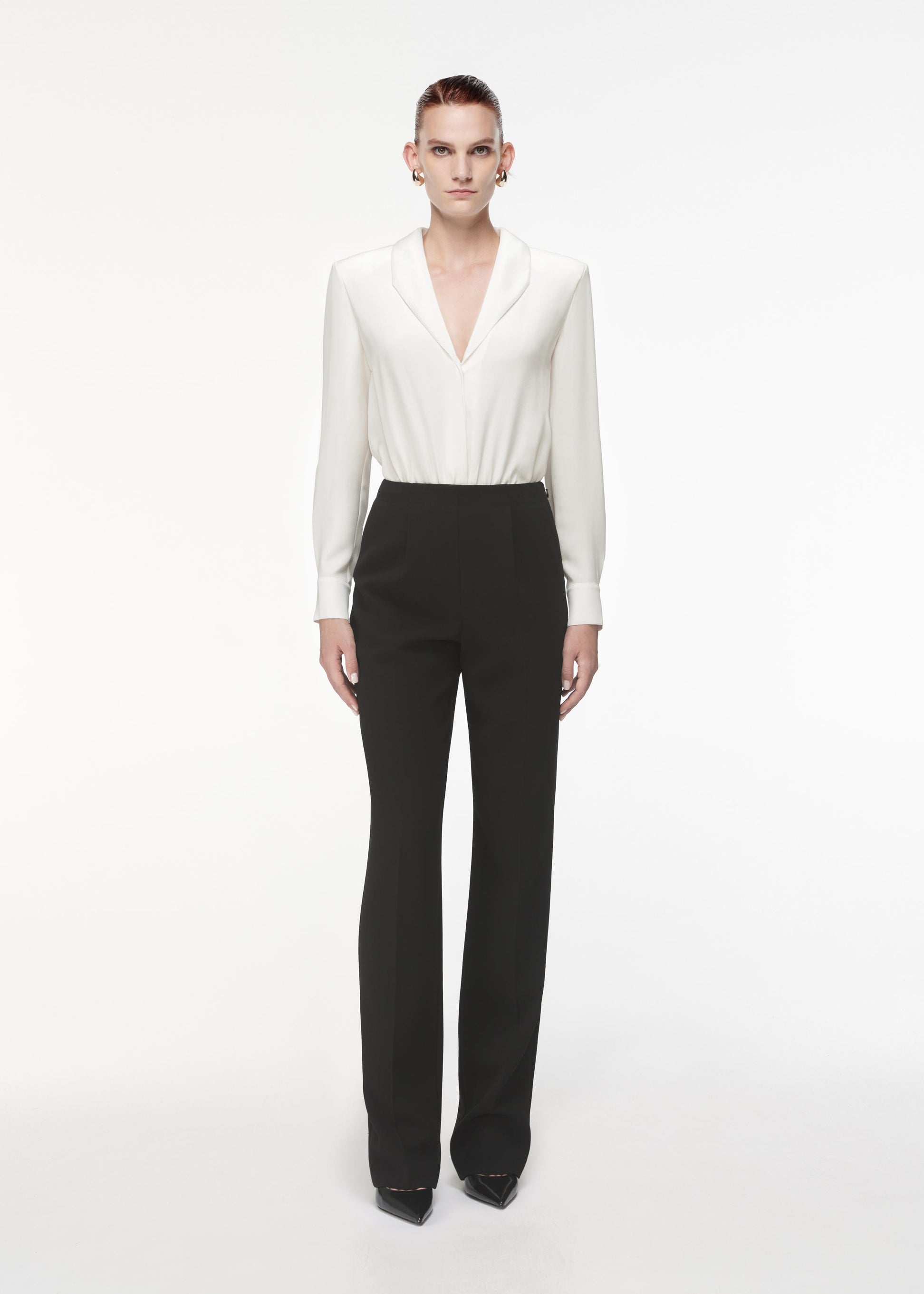 A photograph of a woman wearing a Silk Shirt Bodysuit in White