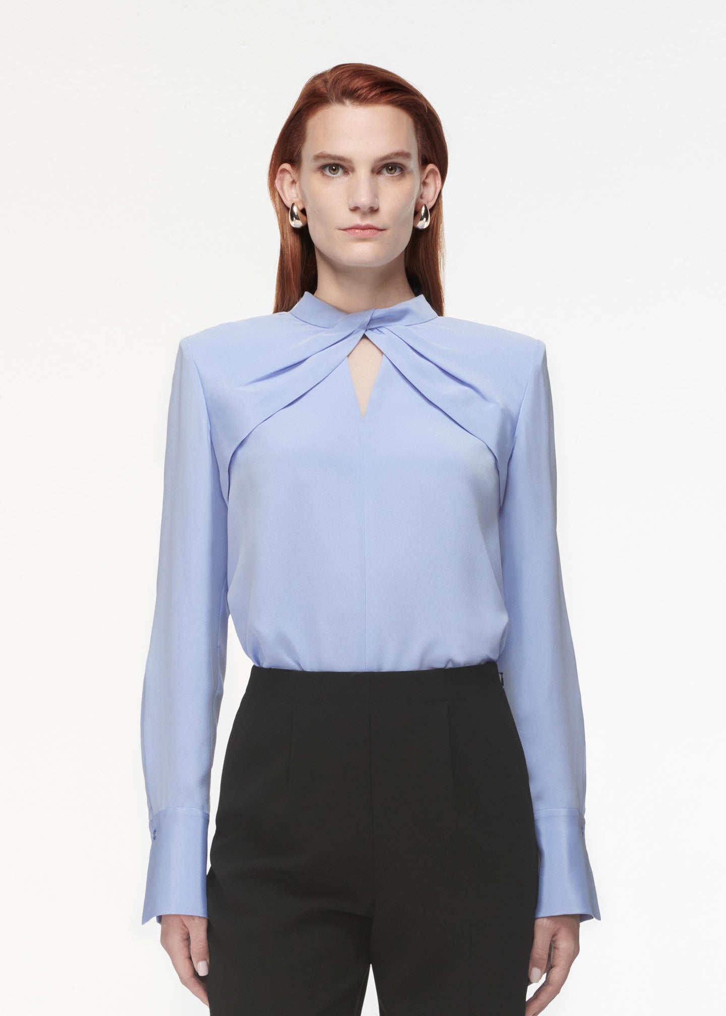 A photograph of a woman wearing a Silk Twist Top in Blue