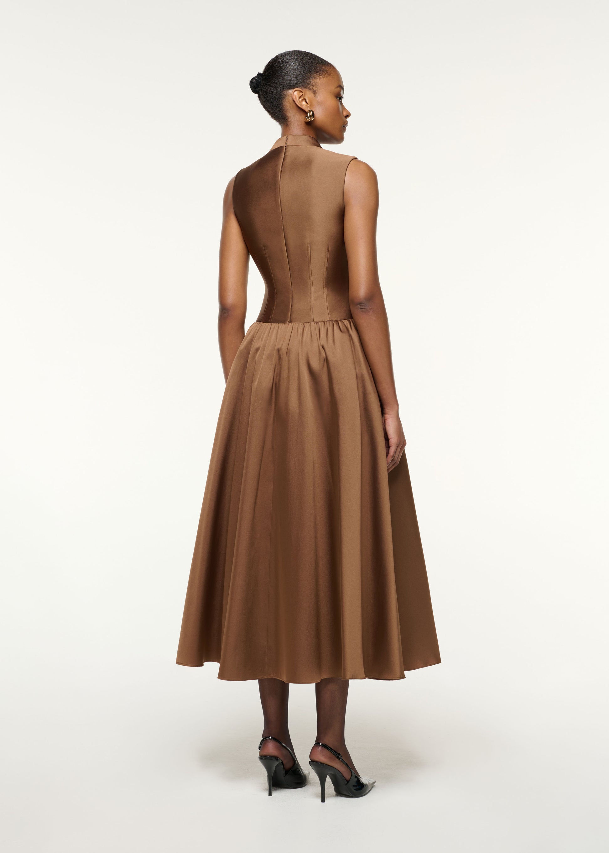 Back view of a model wearing the Dropped Gathered Waist Taffeta Dress in Brown
