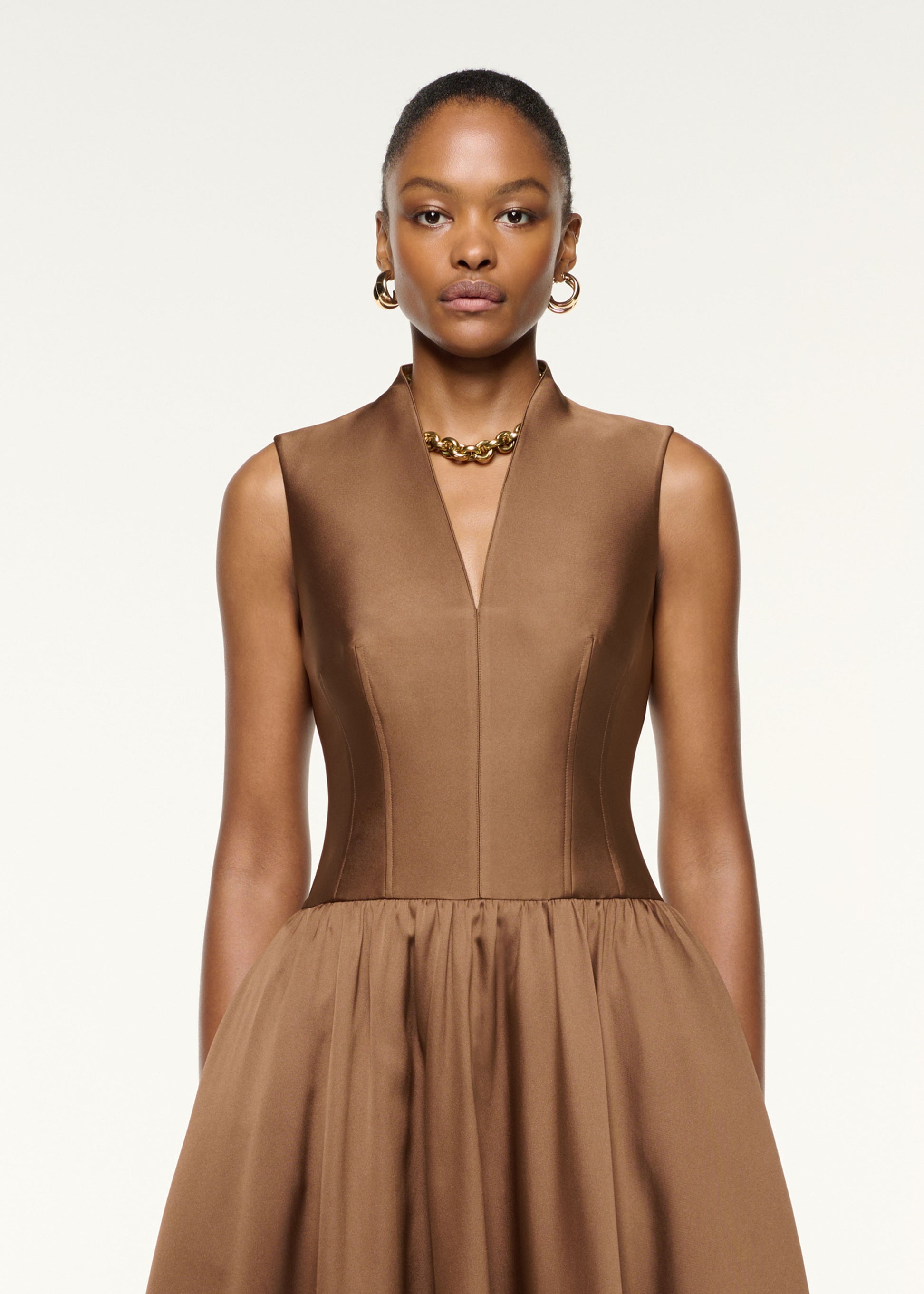 Close up of a model wearing the Dropped Gathered Waist Taffeta Dress in Brown