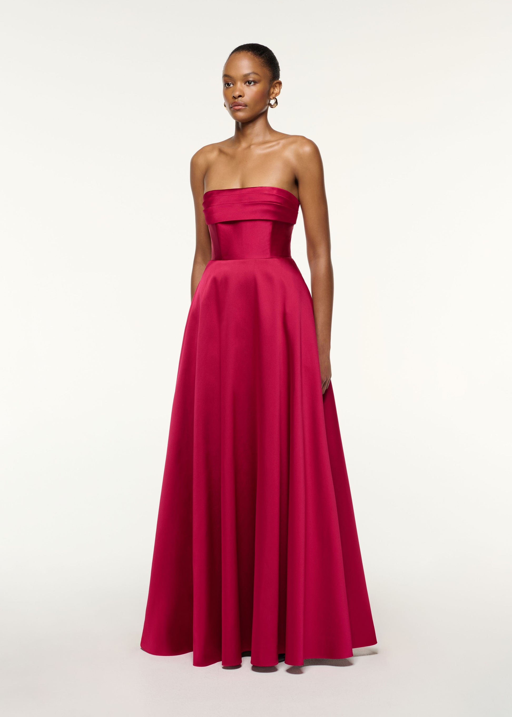 Side view of a model wearing the Pleated Bust Taffeta Evening Gown in Pink