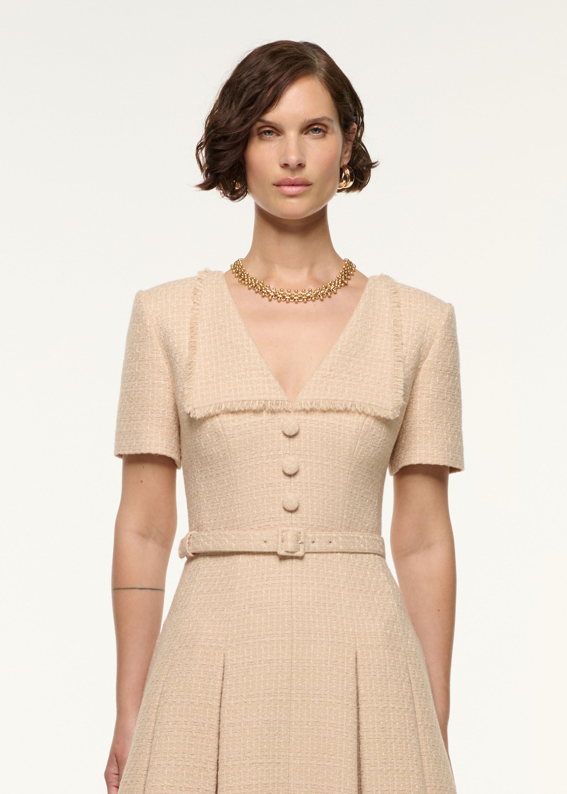 Close up of a model wearing the Folded Collar Belted Boucle Dress in Dark Cream