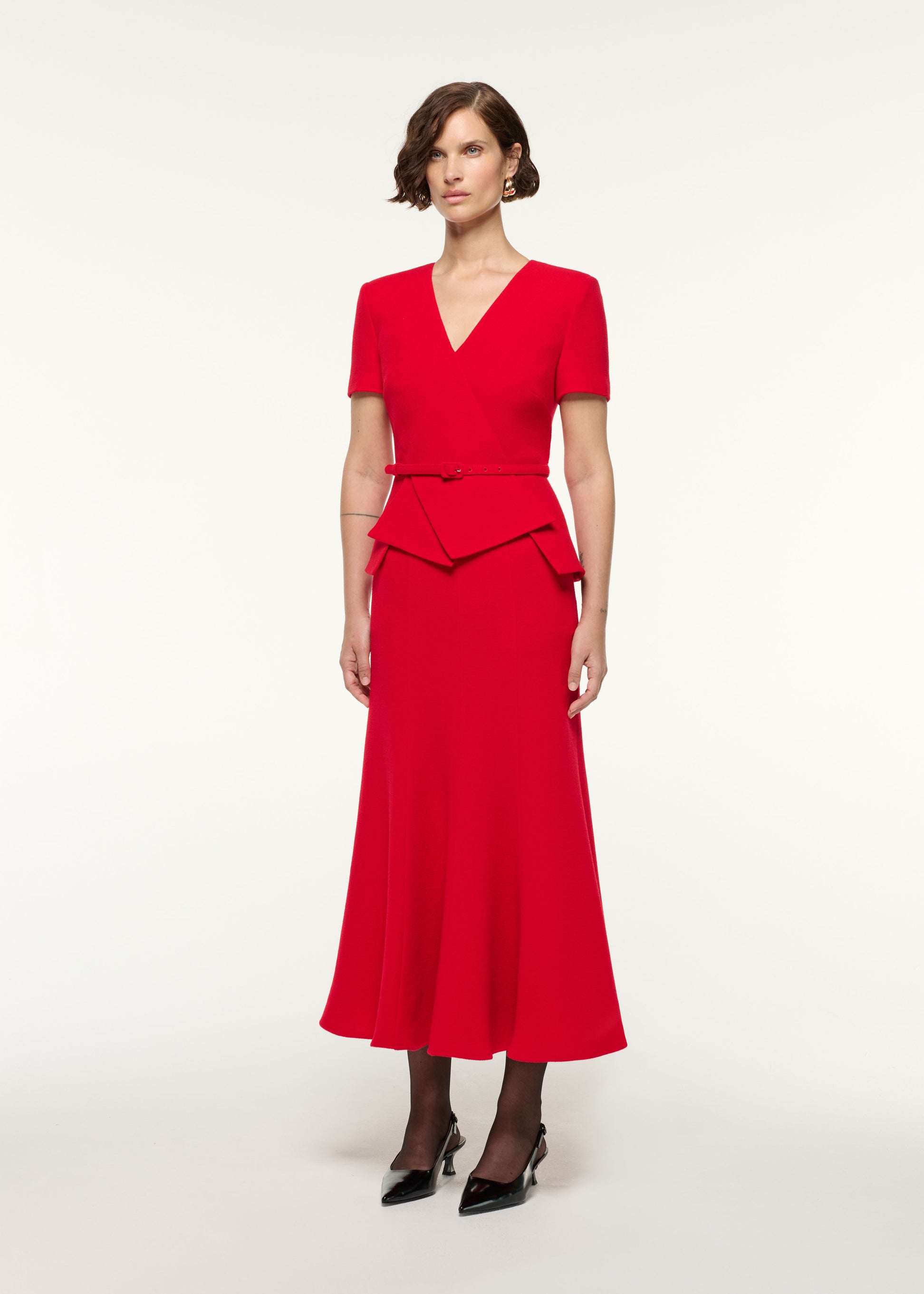 Side view of a model wearing the Wool Origami Peplum Drape Dress in Red