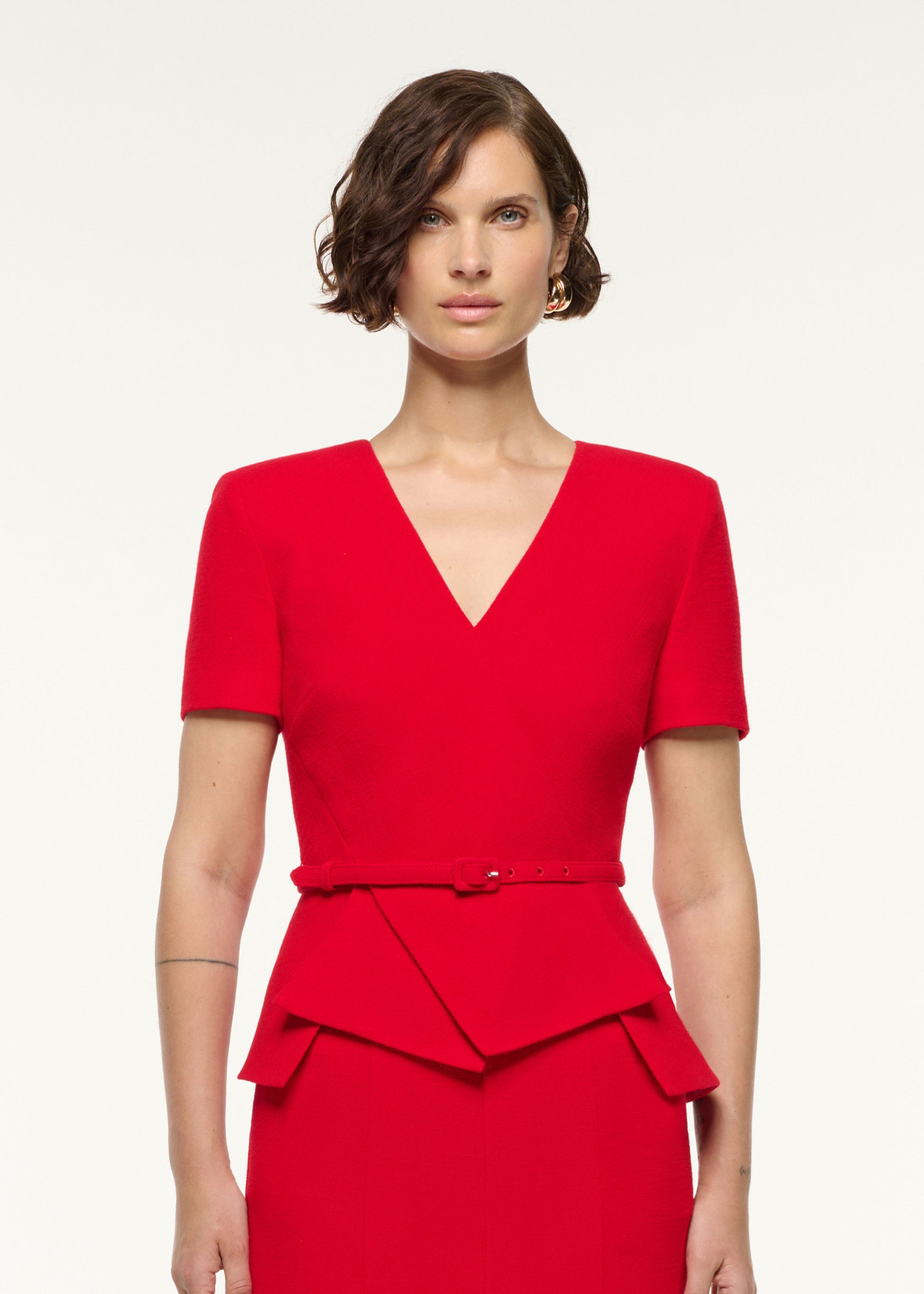 Close up of a model wearing the Wool Origami Peplum Drape Dress in Red