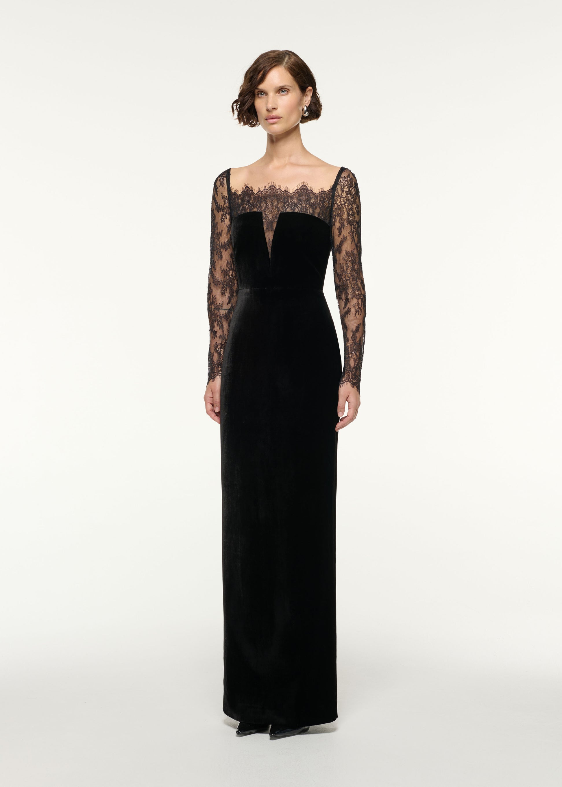 Side view of a model wearing the Scalloped Lace And Velvet Gown in Black