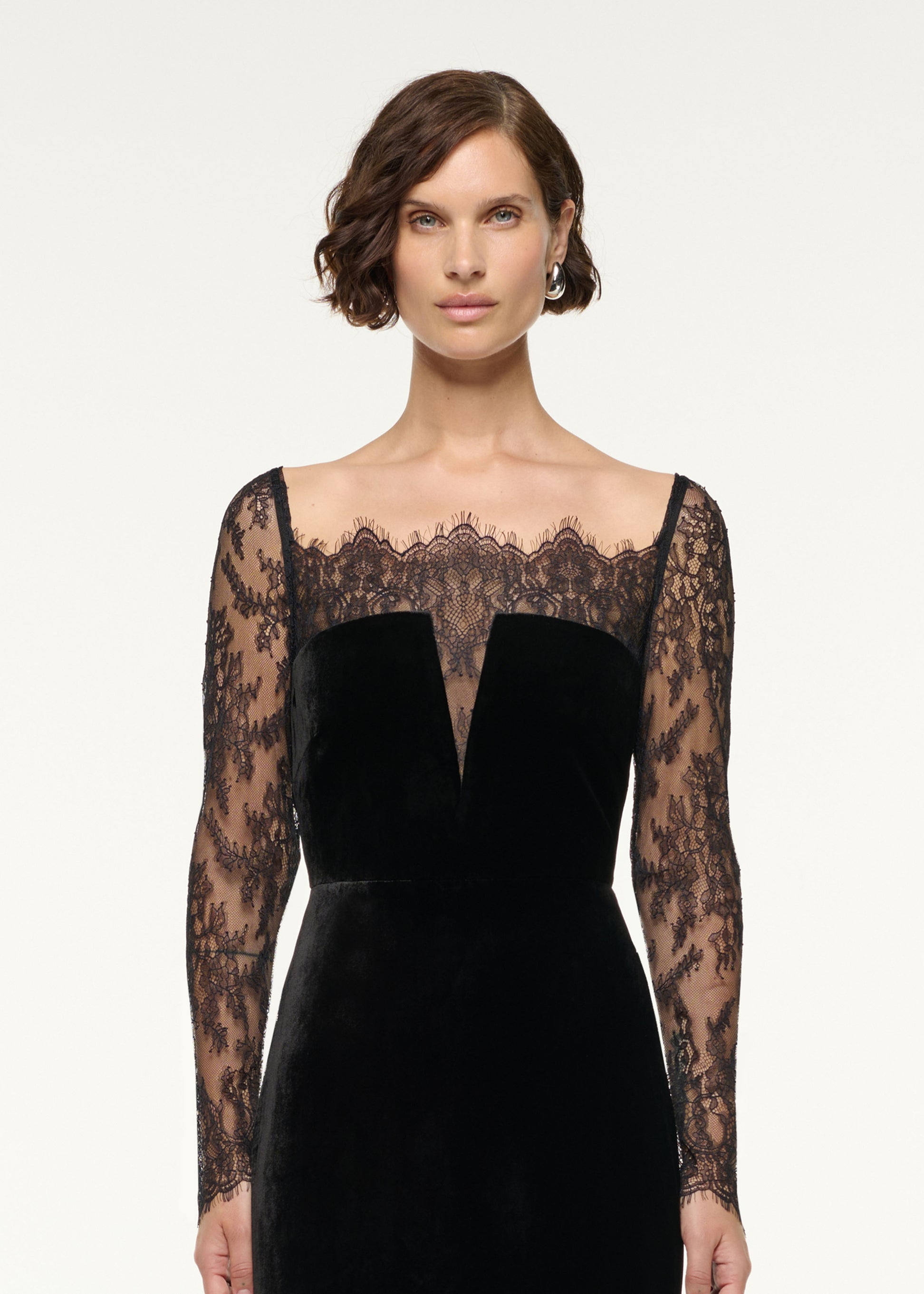 Close up of a model wearing the Scalloped Lace And Velvet Gown in Black