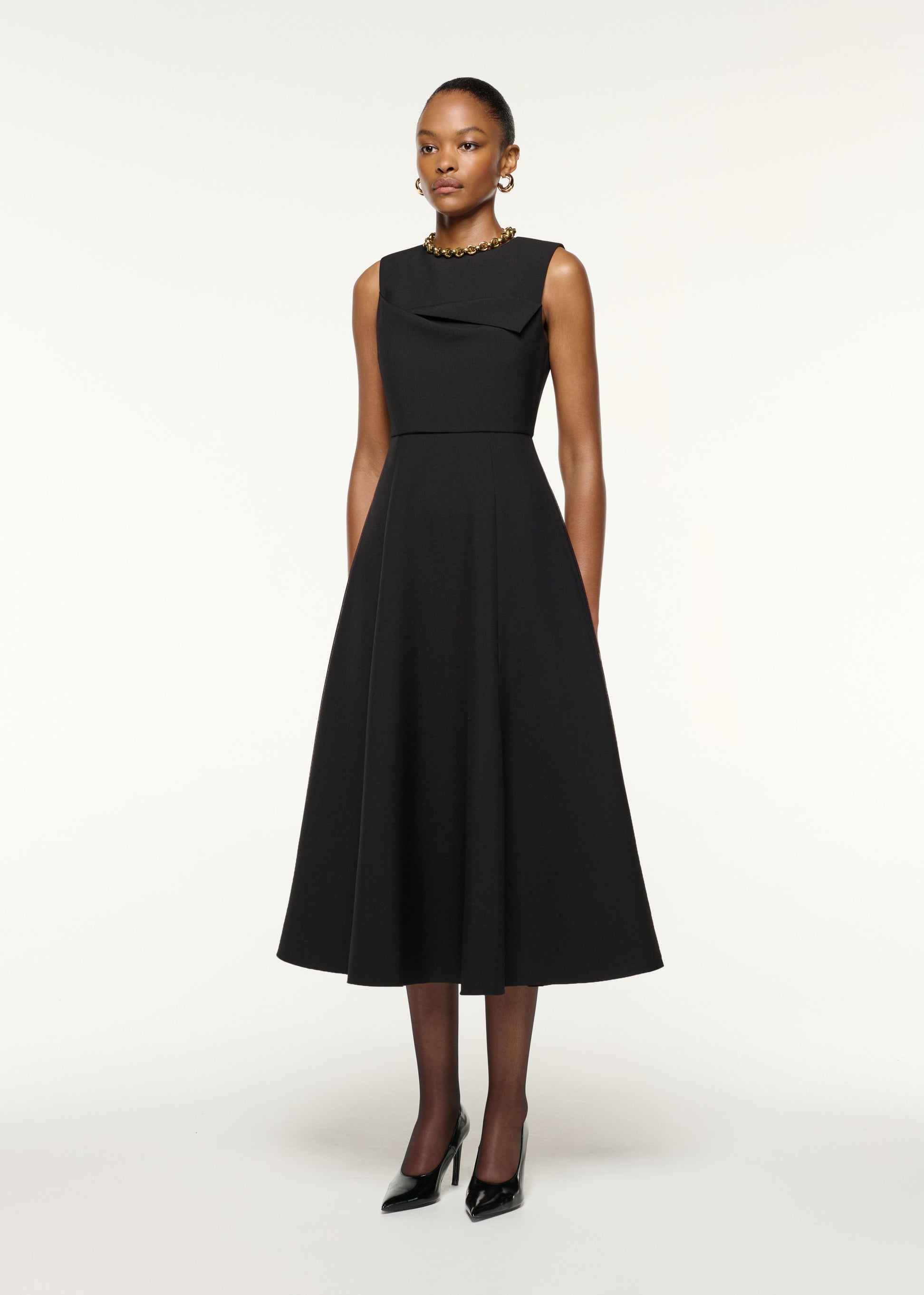 Side view of a model wearing the Origami Bust Line Flared Midi Dress in Black