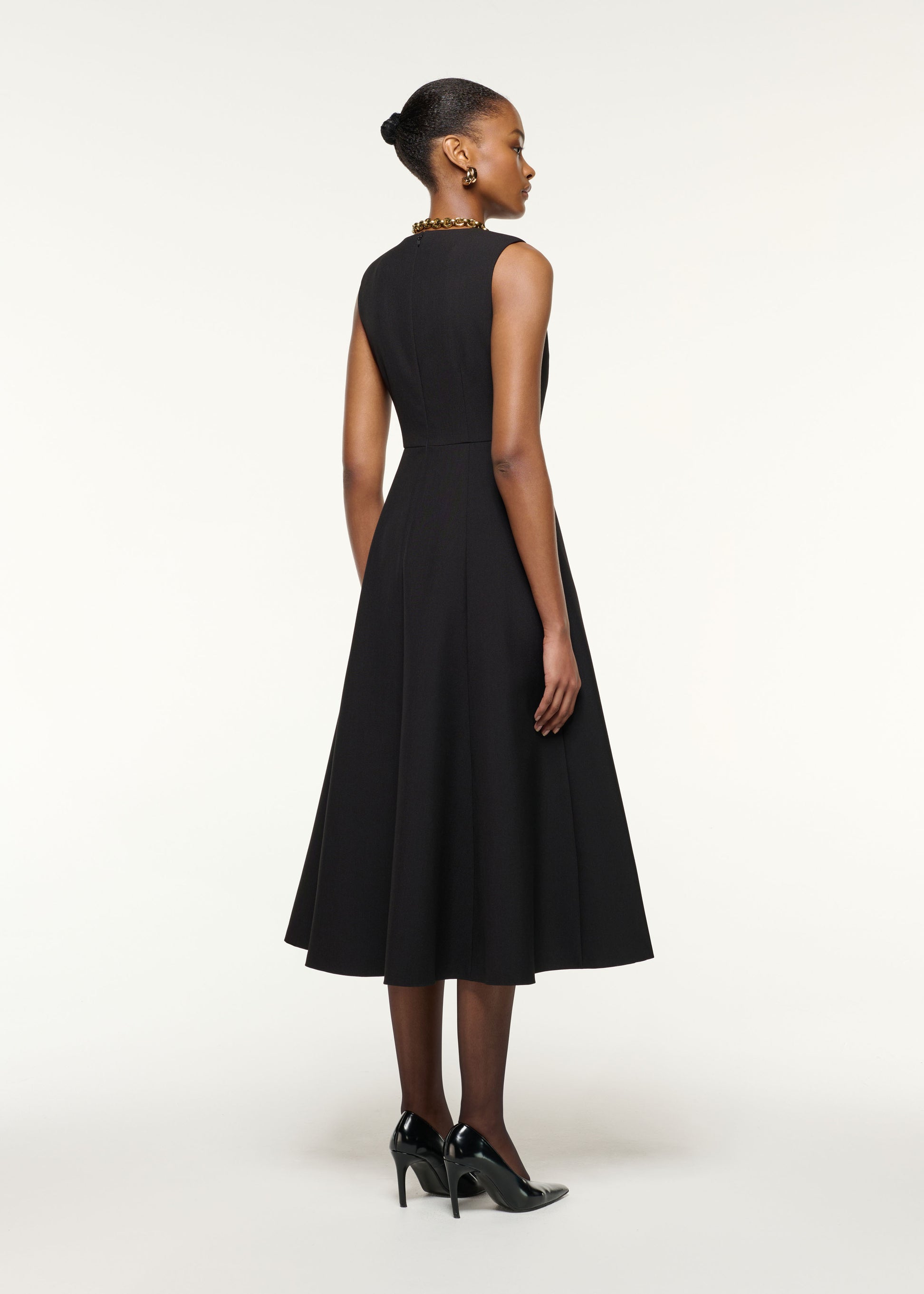 Back view of a model wearing the Origami Bust Line Flared Midi Dress in Black