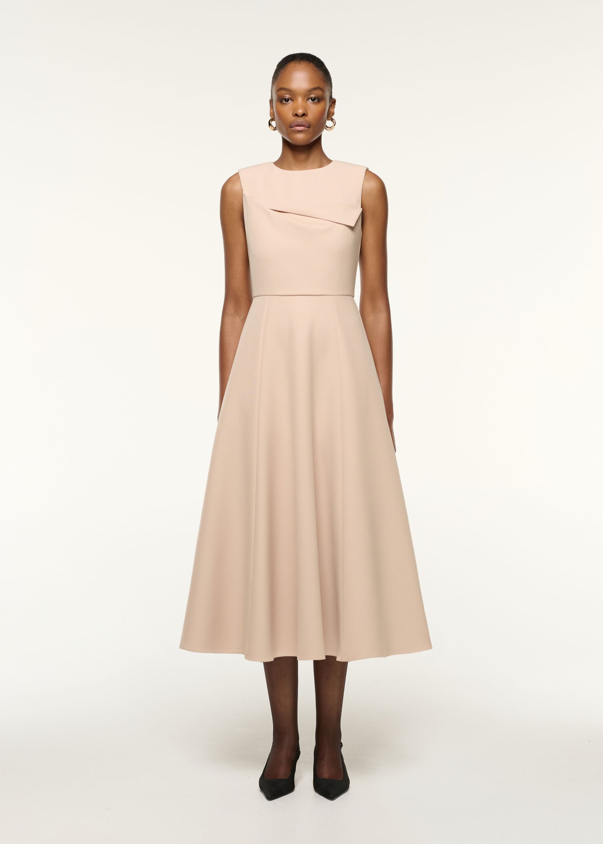Front view of a model wearing the Origami Bust Line Flared Midi Dress in Cream