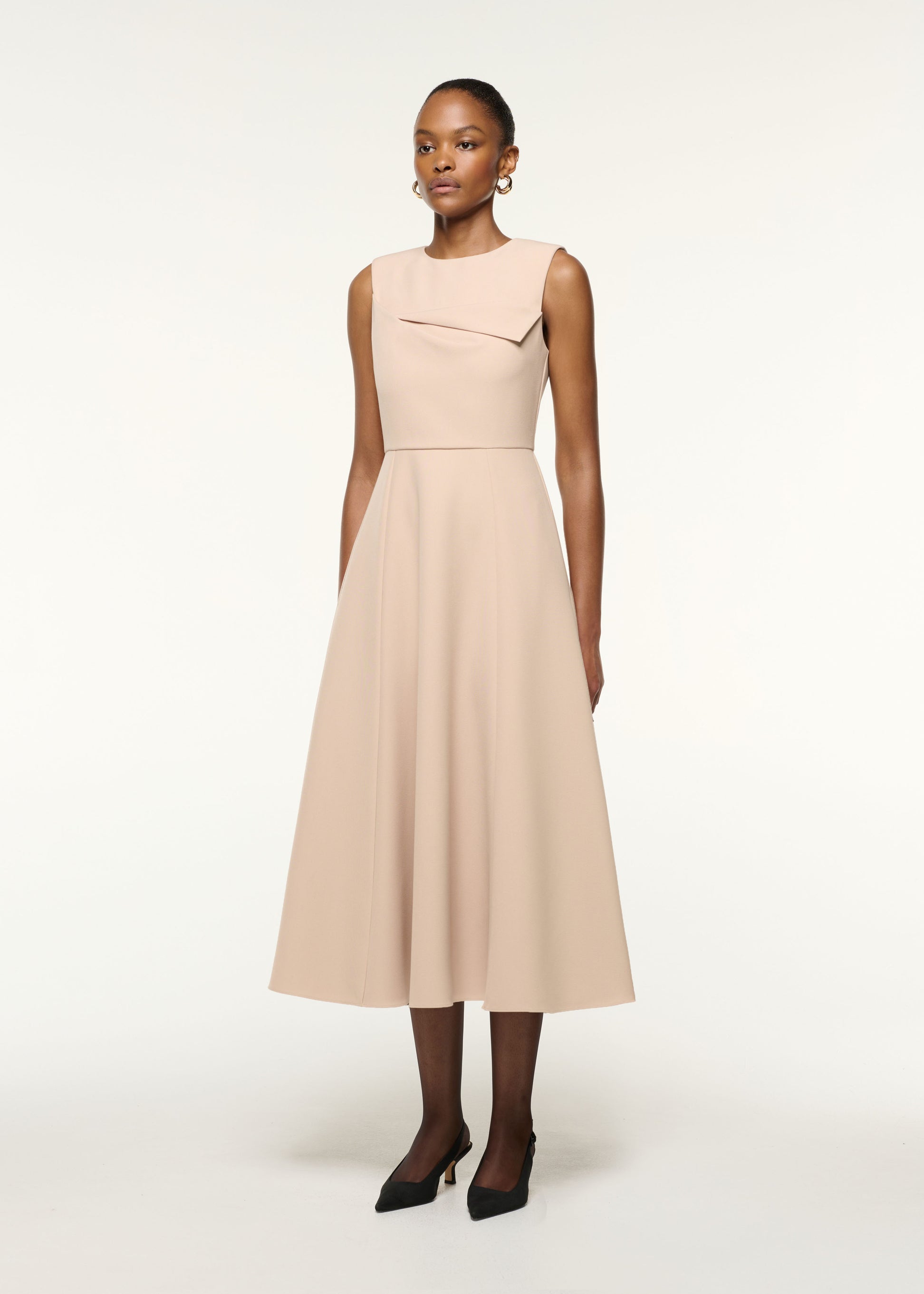 Side view of a model wearing the Origami Bust Line Flared Midi Dress in Cream