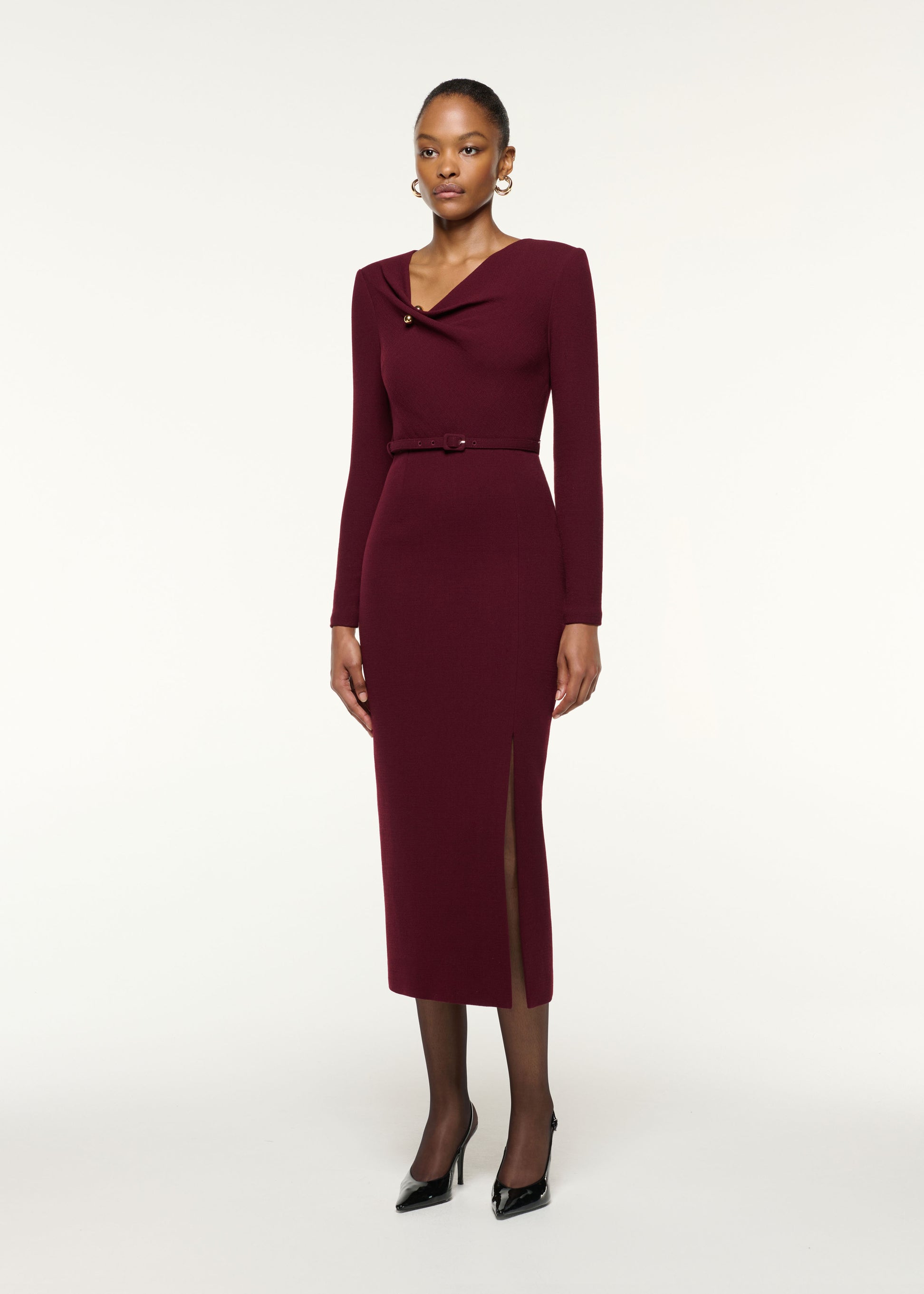 Side view of a model wearing the Asymmetrical Draped Neck Belted Wool Dress in Mulberry