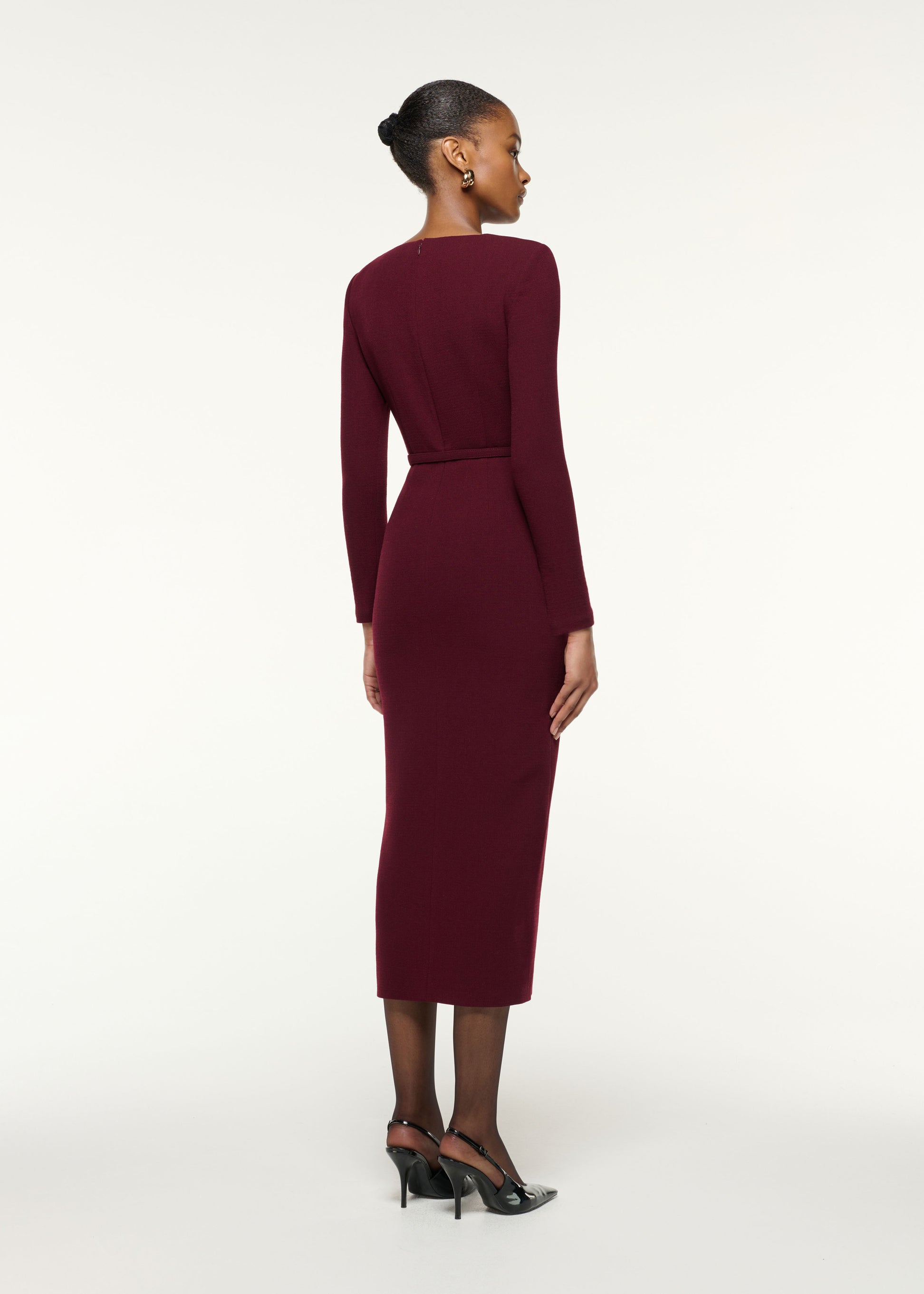 Back view of a model wearing the Asymmetrical Draped Neck Belted Wool Dress in Mulberry