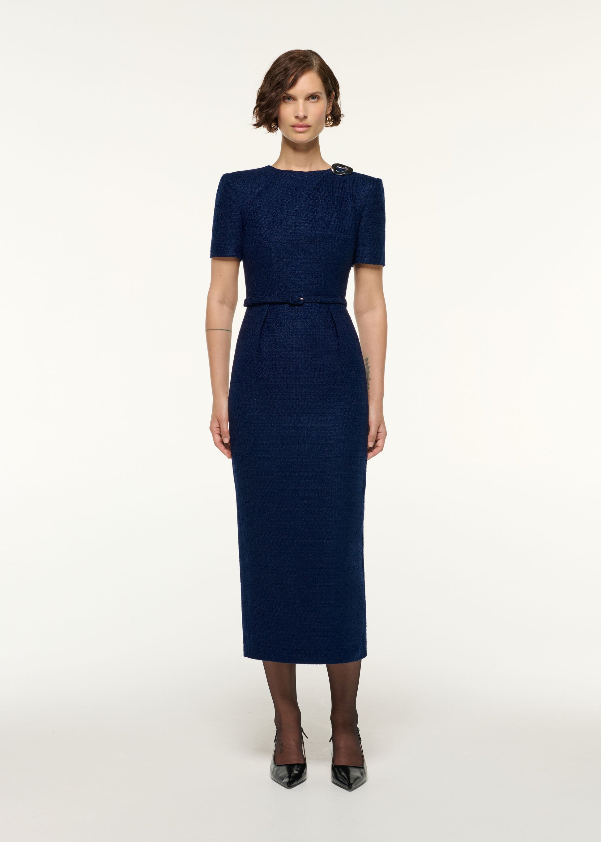 Front view of a model wearing the Twisted Silver Brooch Belted Boucle Dress in Navy