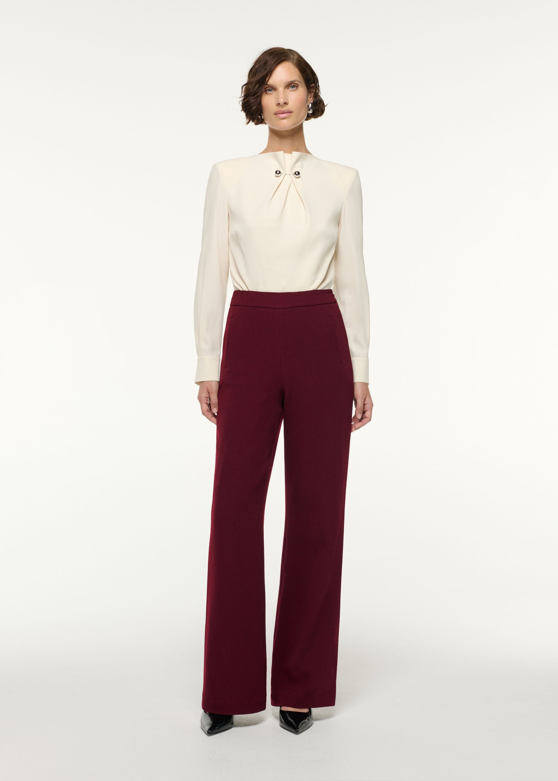 Front view of a model wearing the Gathered Silver Brooch Blouson Bodysuit in Cream