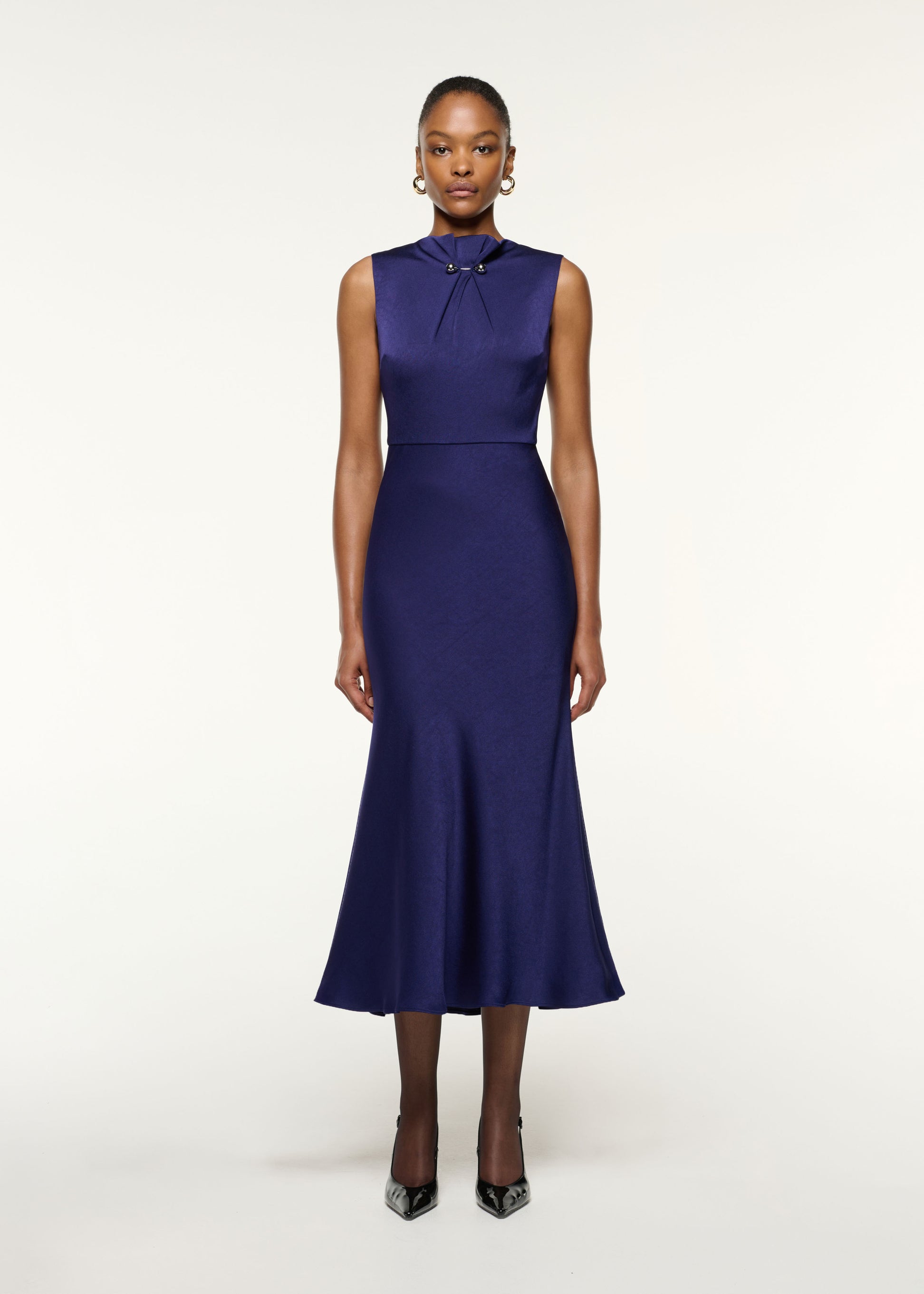 Front view of a model wearing the Gathered Silver Brooch Fit And Flare Dress in Navy
