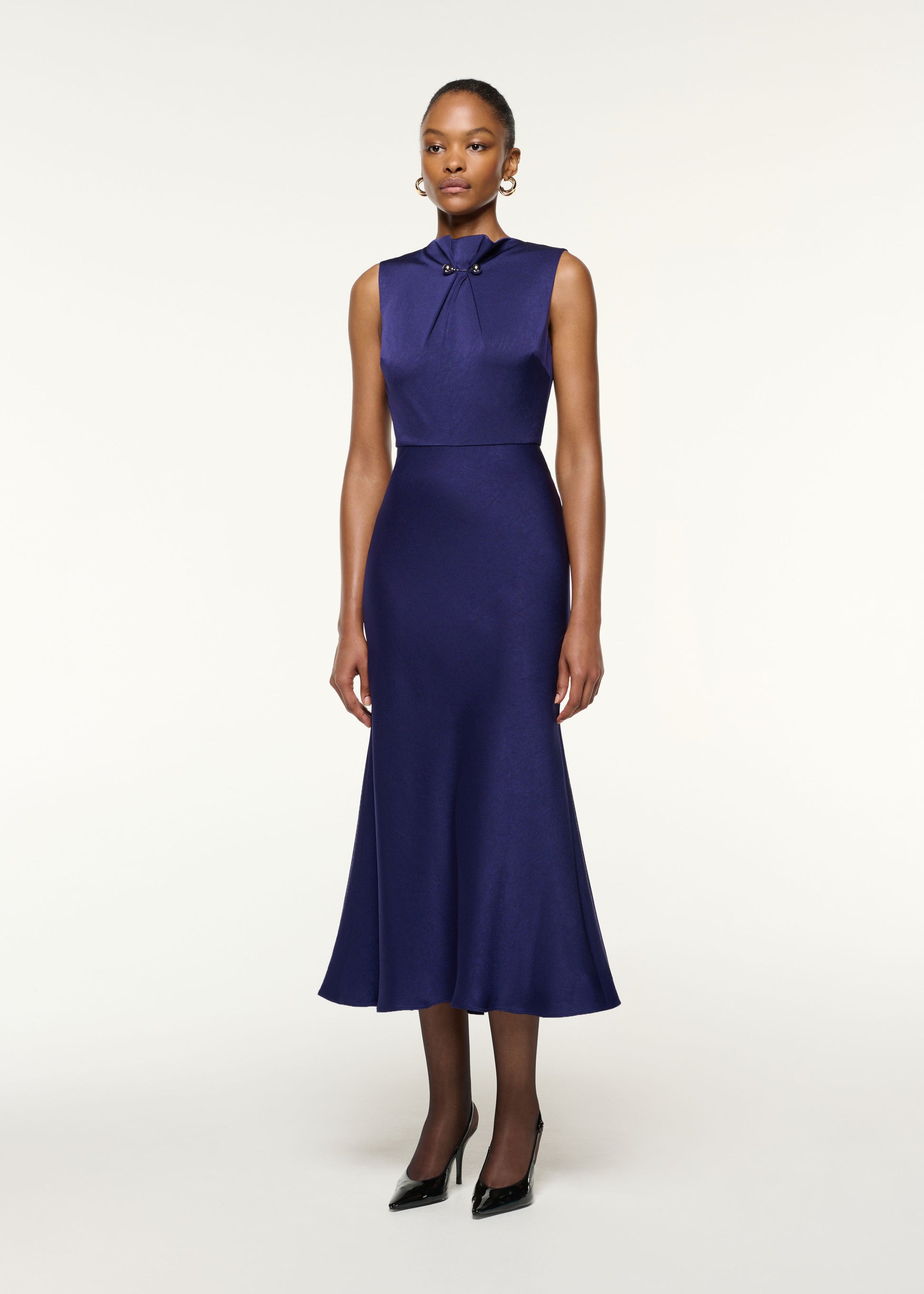 Side view of a model wearing the Gathered Silver Brooch Fit And Flare Dress in Navy