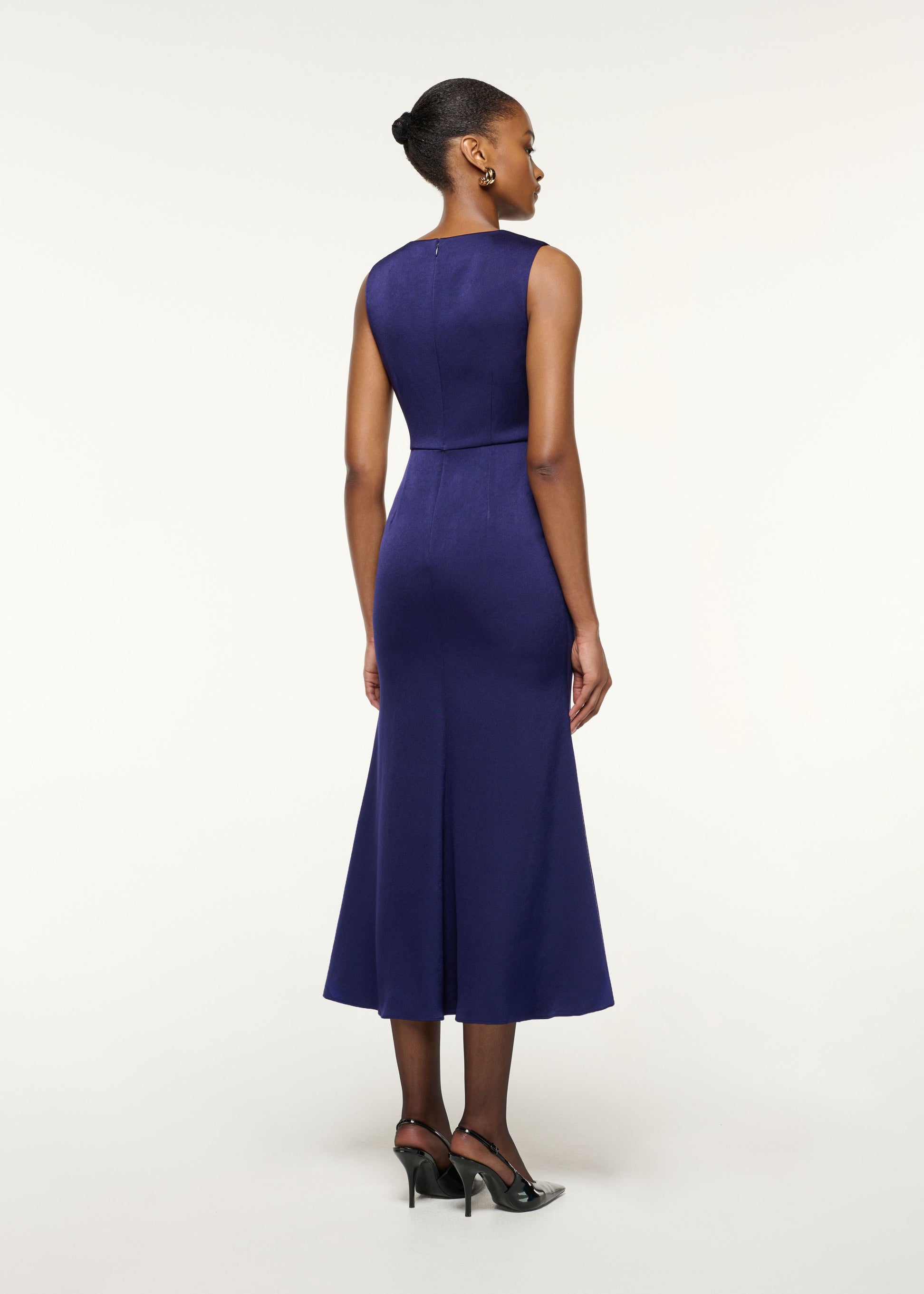 Back view of a model wearing the Gathered Silver Brooch Fit And Flare Dress in Navy