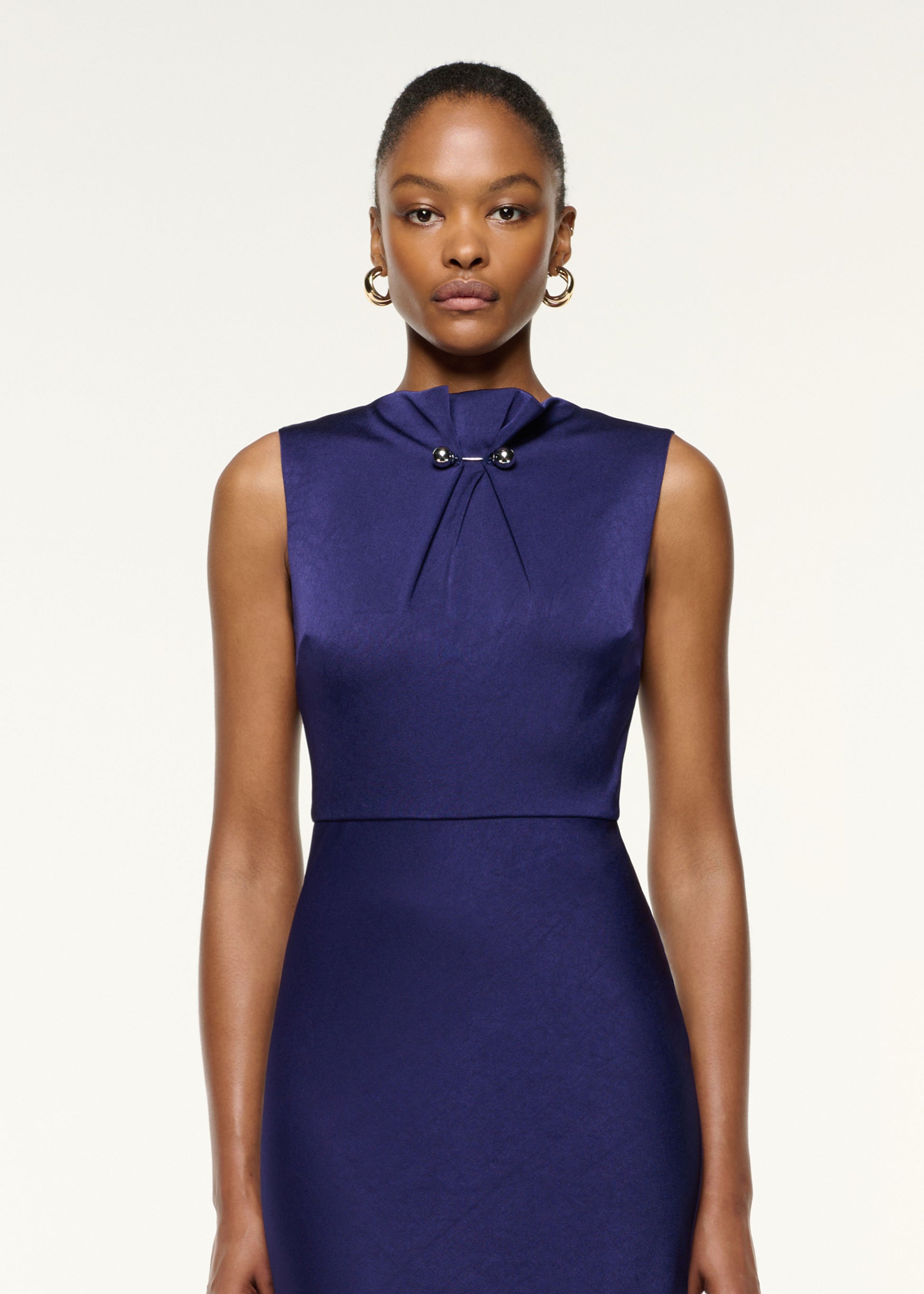 Close up of a model wearing the Gathered Silver Brooch Fit And Flare Dress in Navy