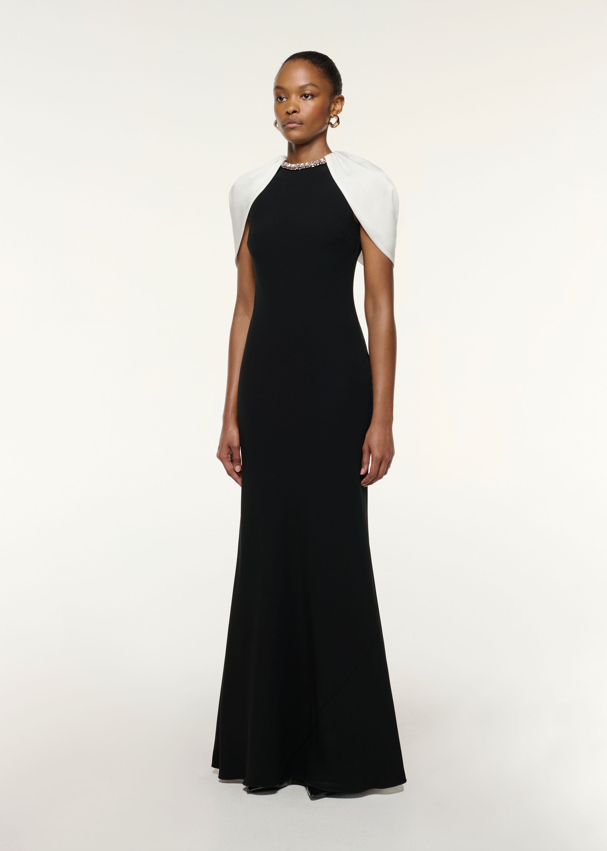 Side view of a model wearing the Gathered Shawl Crystal Trim Neckline Gown in Monochrome