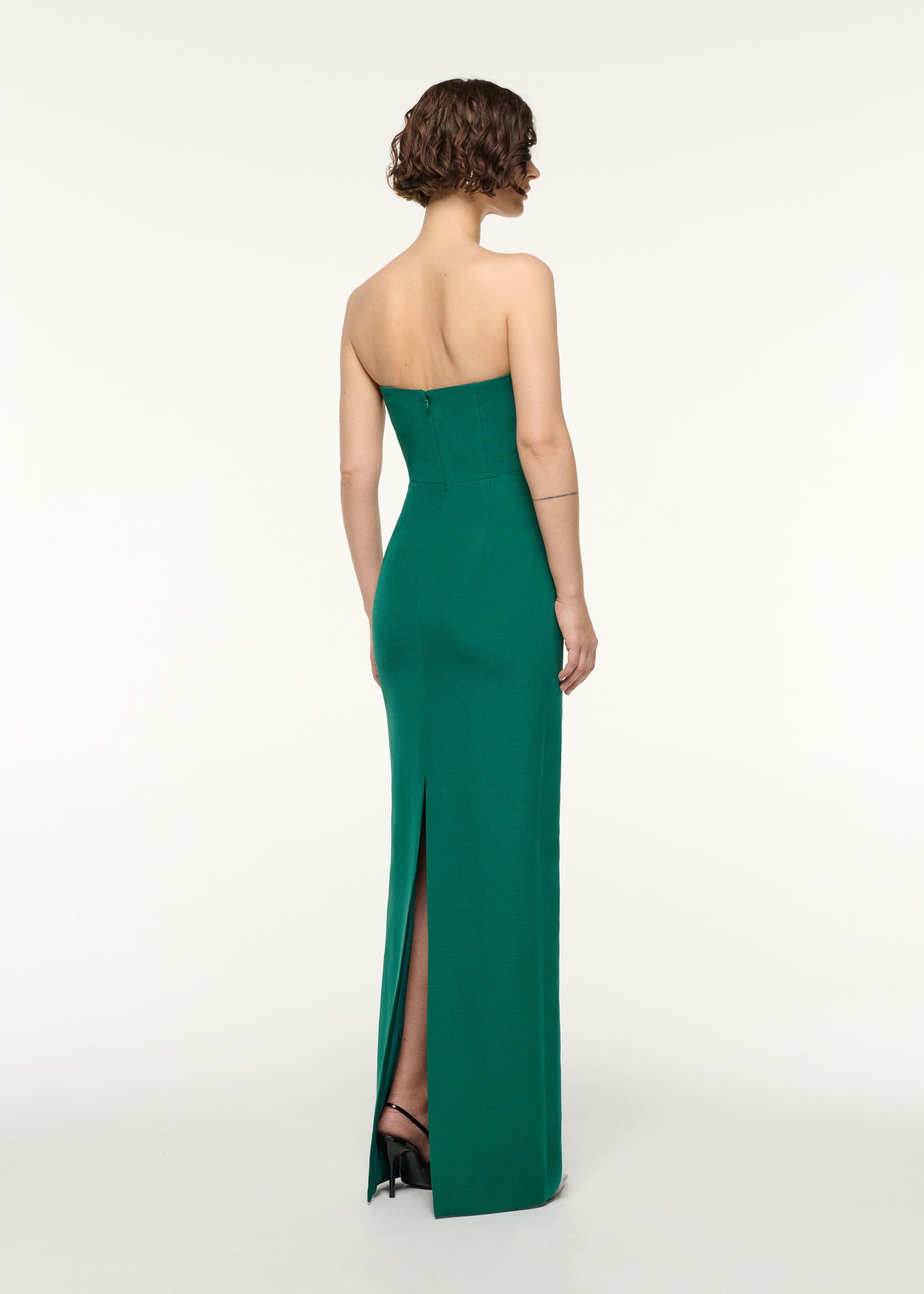 Back view of a model wearing the Asymmetrical Fold Wool Silk Gown in Green